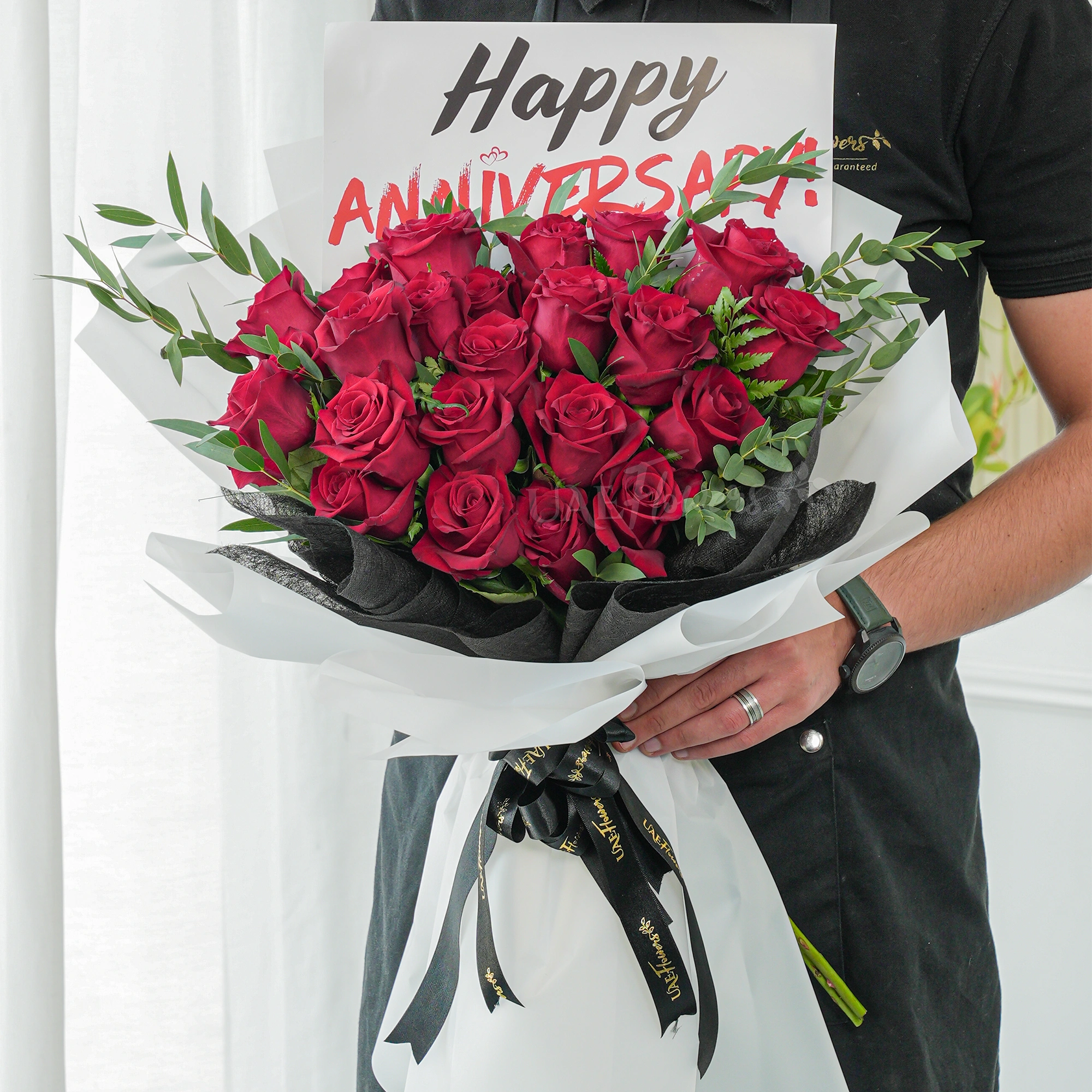 Bouquet of 20 red roses with green fillers in paper packing