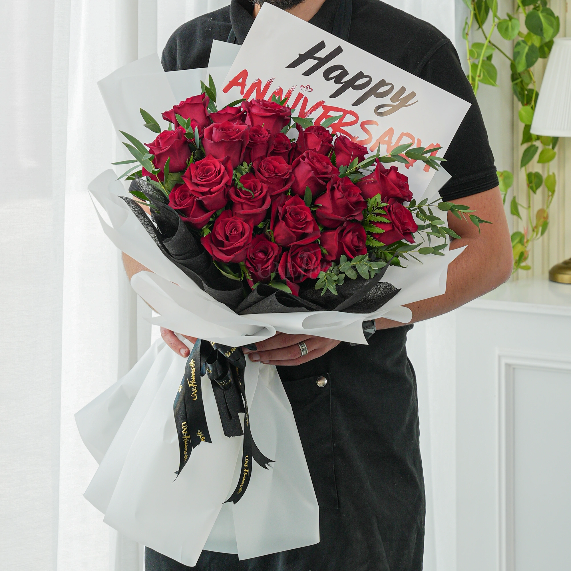 Bouquet of 20 red roses with green fillers in paper packing