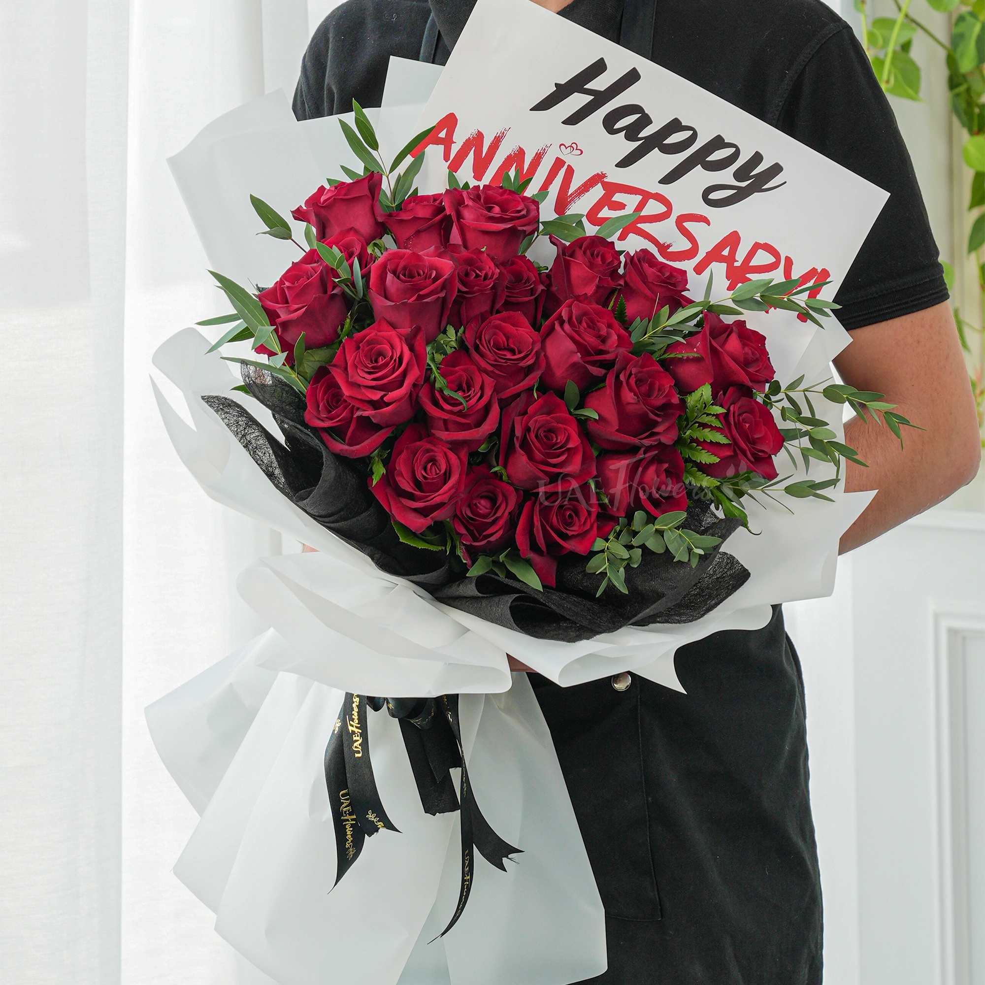 Bouquet of 20 red roses with green fillers in paper packing