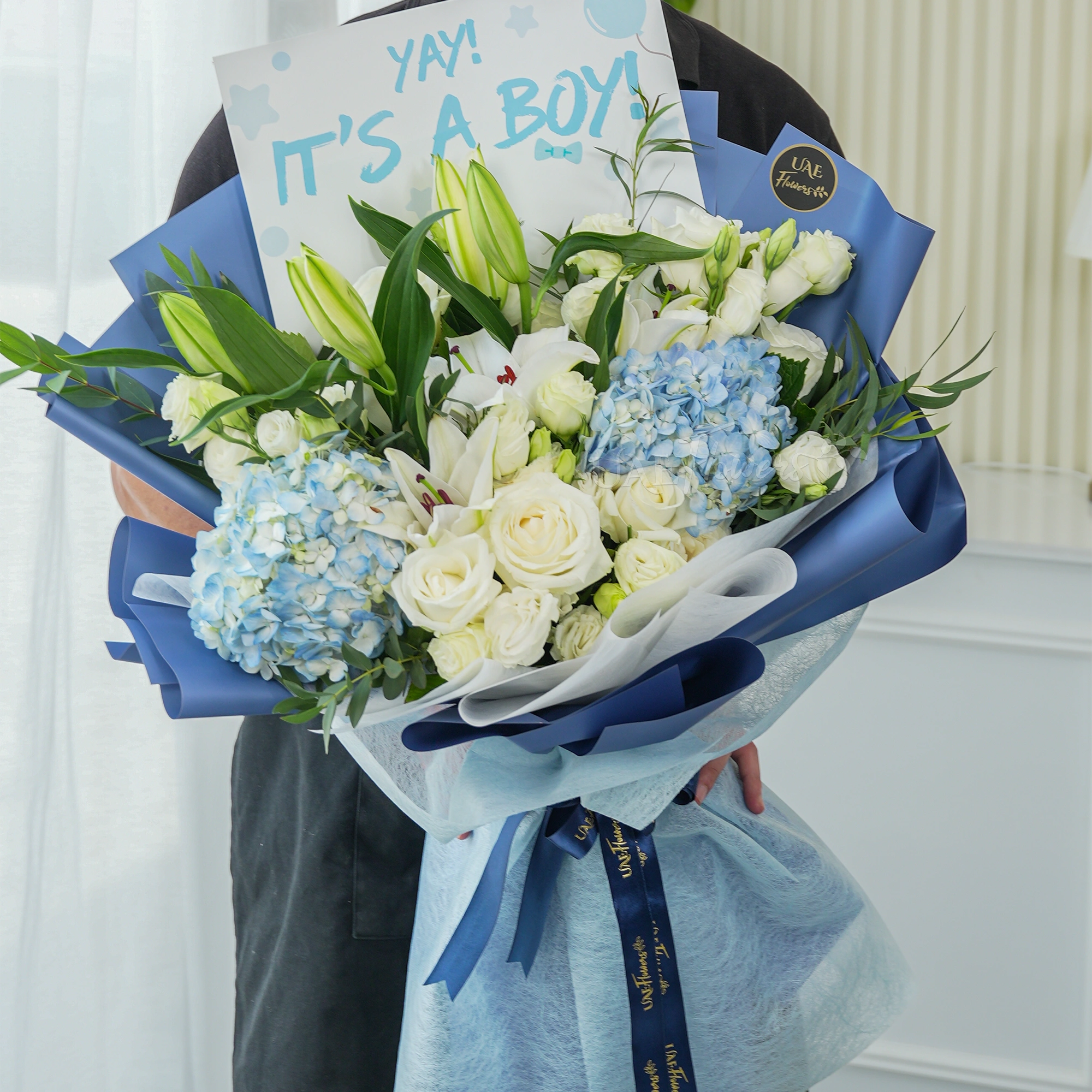 Bouquet of 2 blue hydrangeas, 2 white lilies, 5 white roses and 3 white spray roses with green fillers