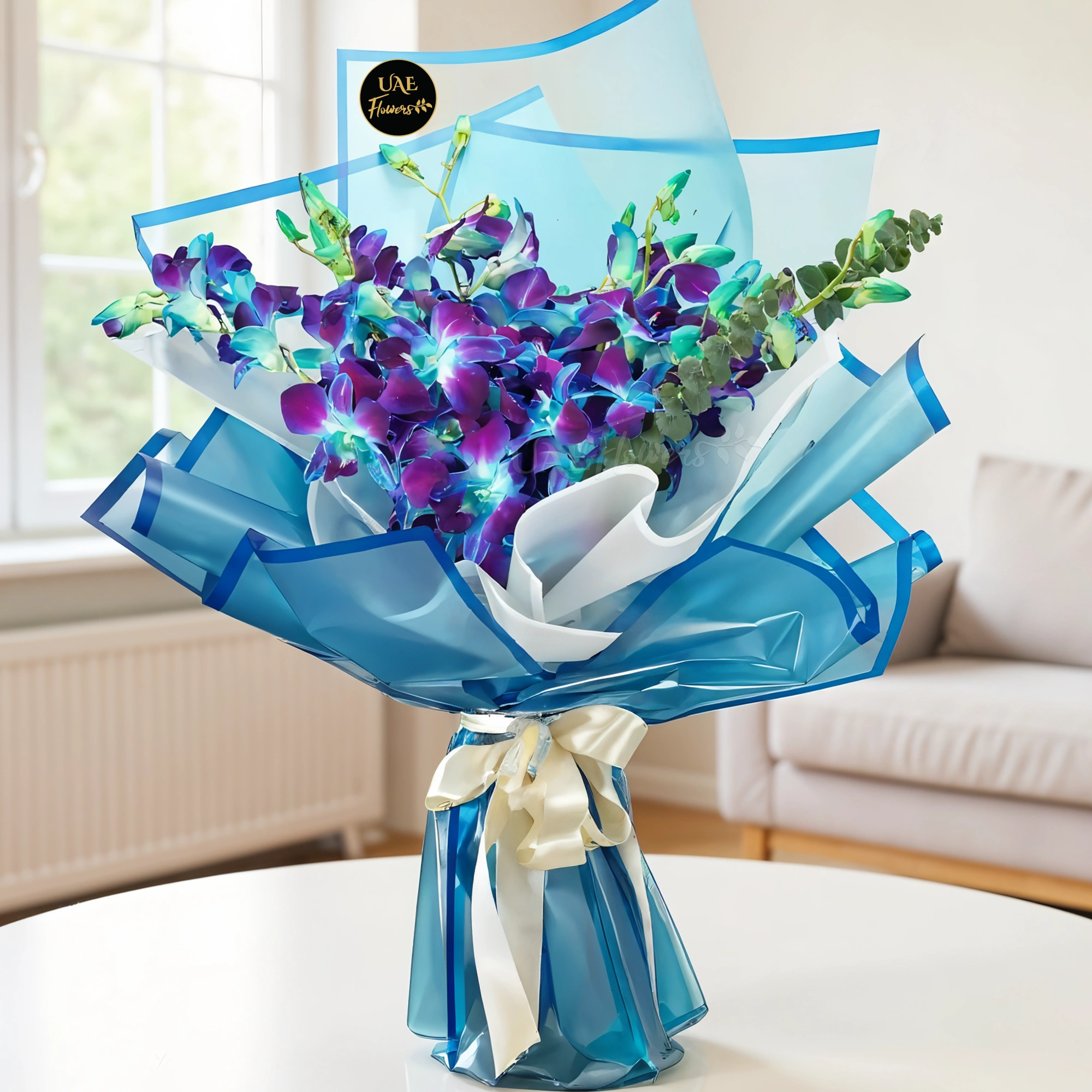 A bouquet of 10 blue orchids with fillers in blue and white wrapping paper tied with white ribbons