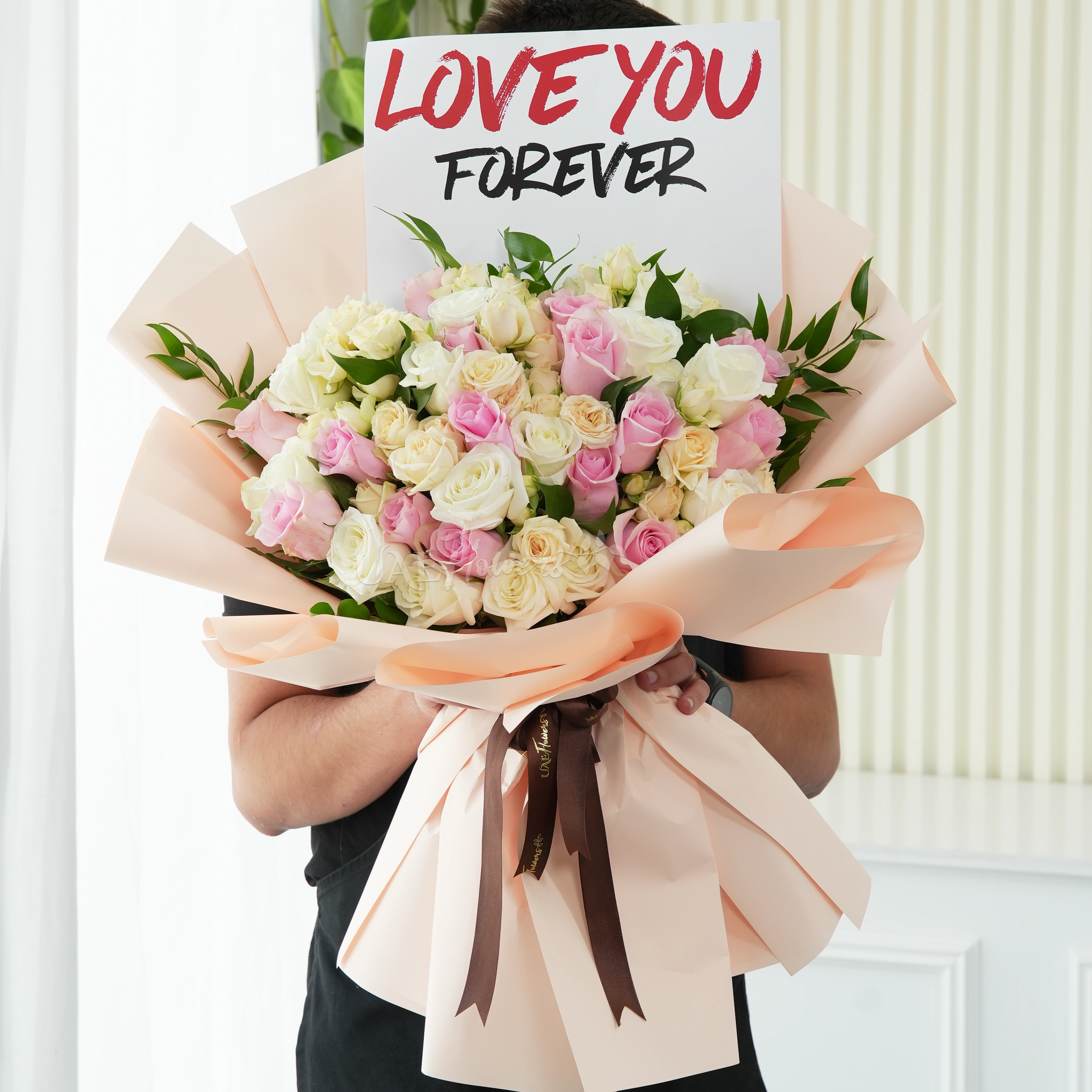 Bouquet of 40 pink, peach and white roses with greens in nice wrapping