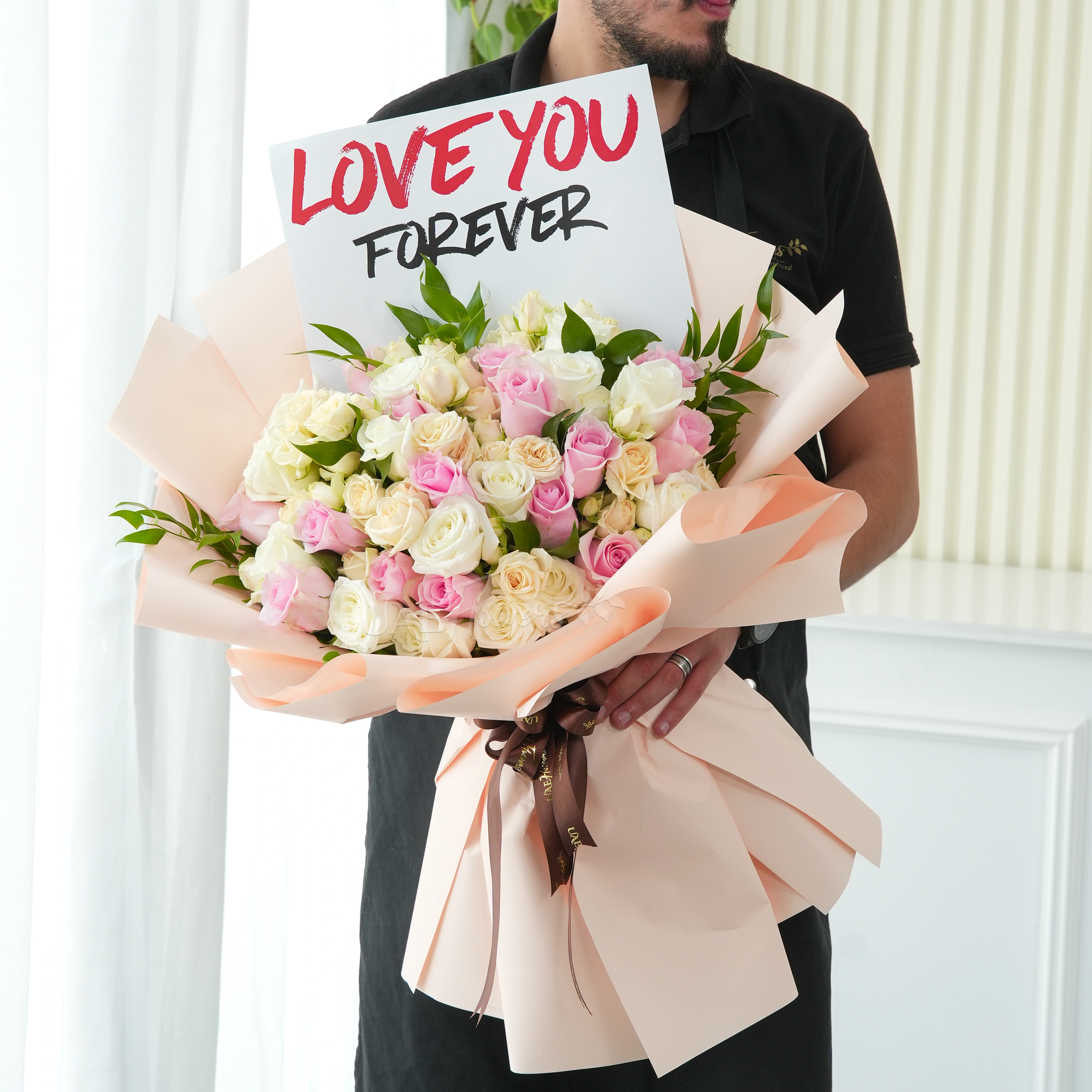Bouquet of 40 pink, peach and white roses with greens in nice wrapping