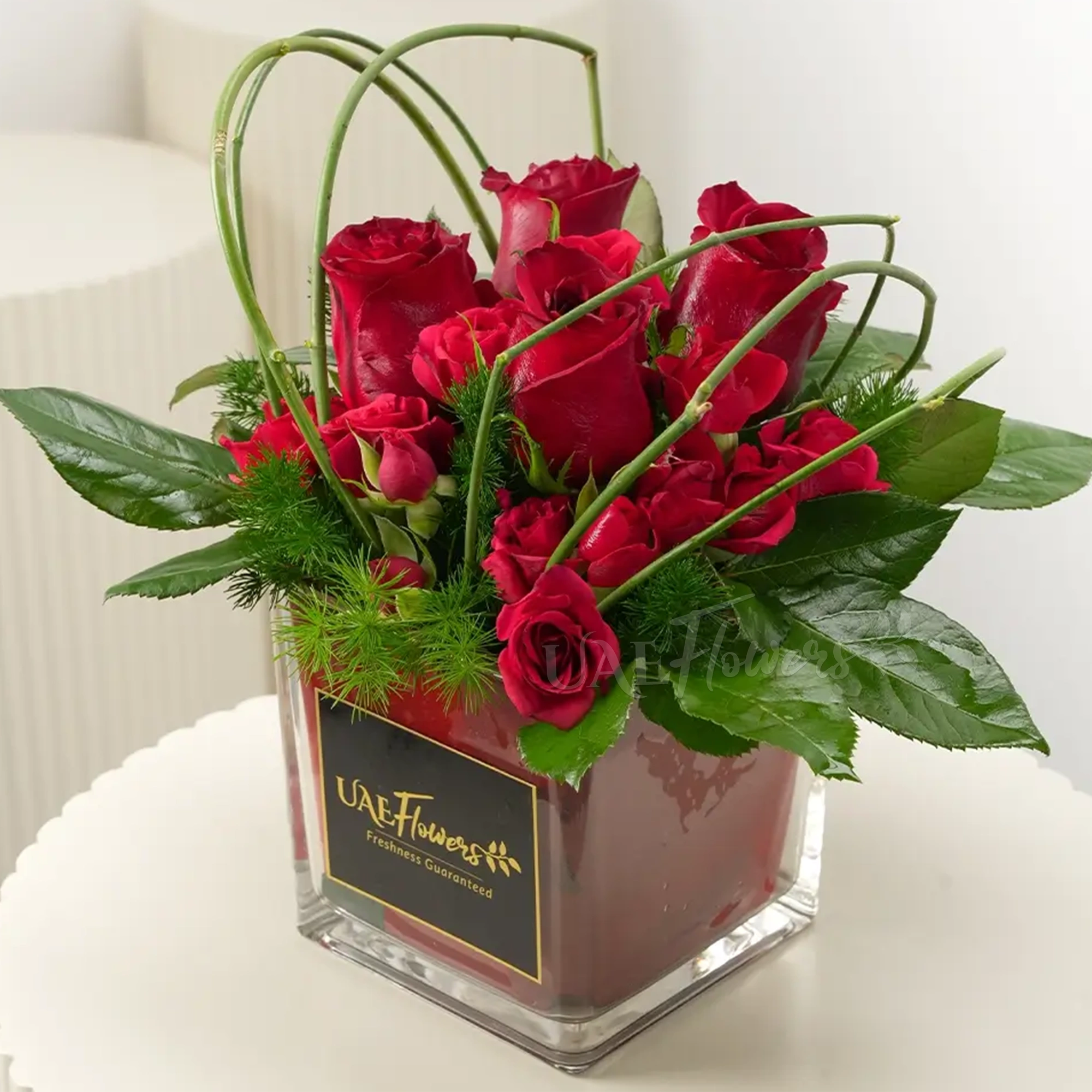 4 Red Roses in a mini-cube vase with greens & steel grass