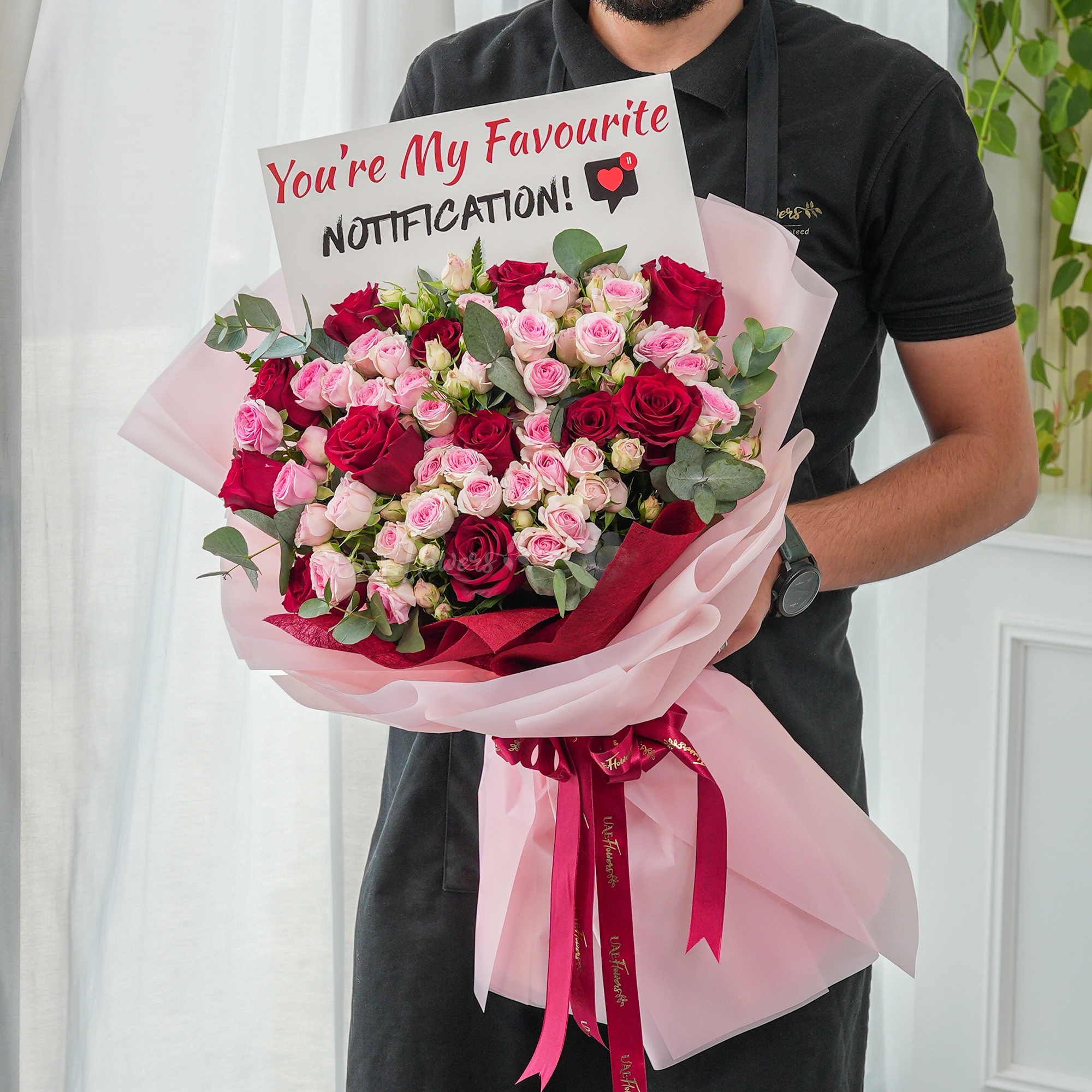 Bouquet of 12 red roses and 10 pink spray roses with green fillers.