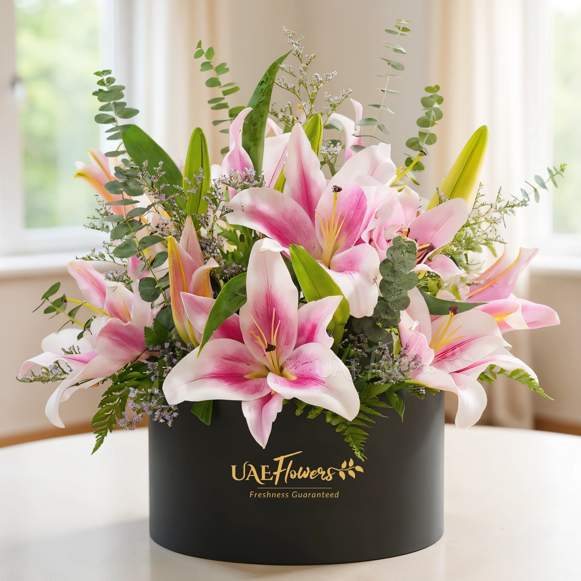 5 pink lilies with eucalyptus leaf and limonium fillers in a black round box