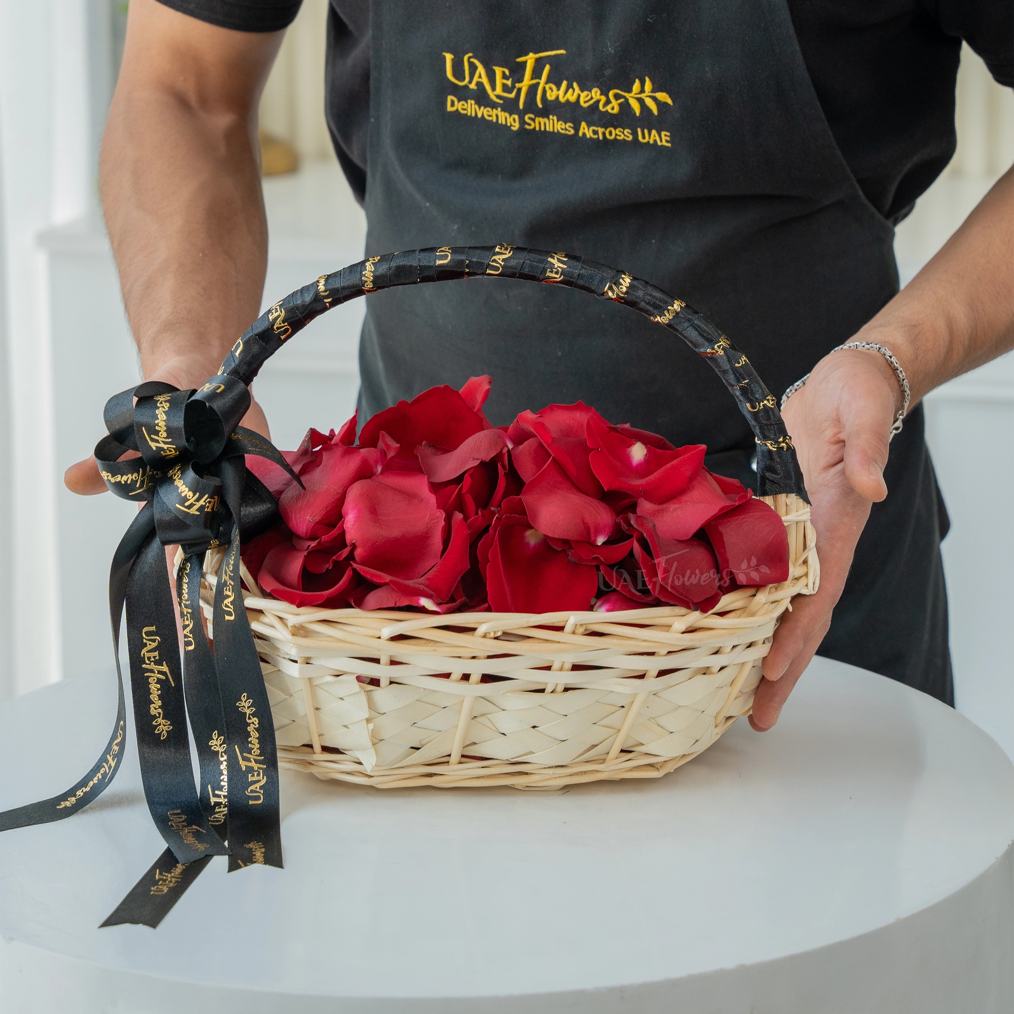 red rose petals arranged in a handled basket