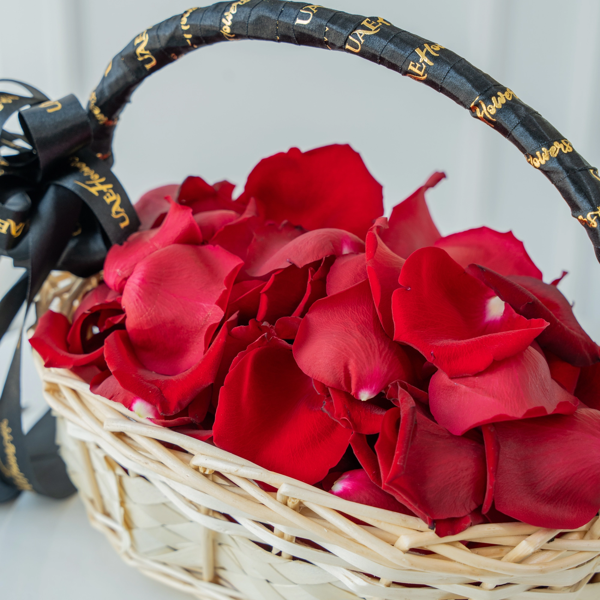 red rose petals arranged in a handled basket