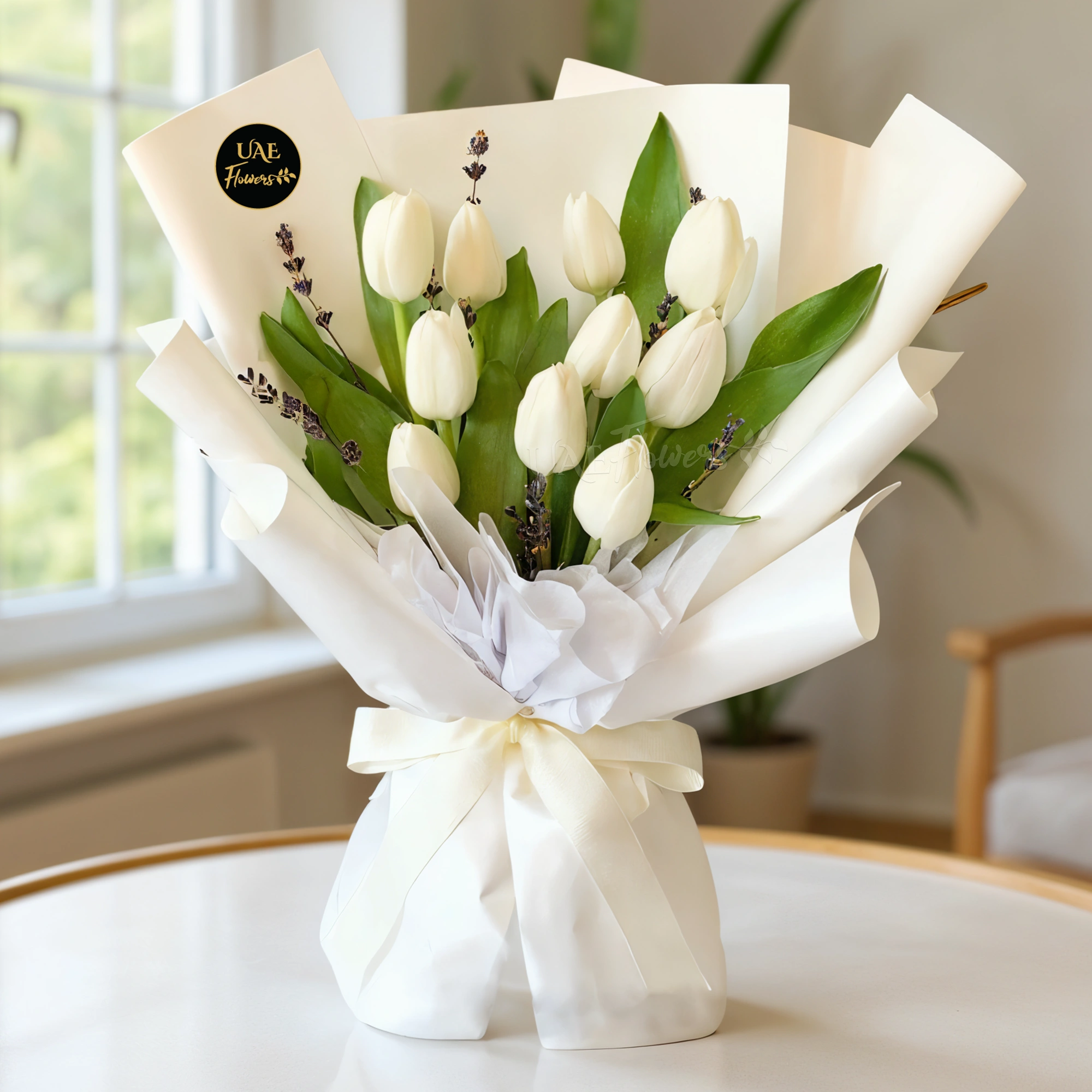A bouquet of 10 white tulips in white wrapping paper tied with white ribbon