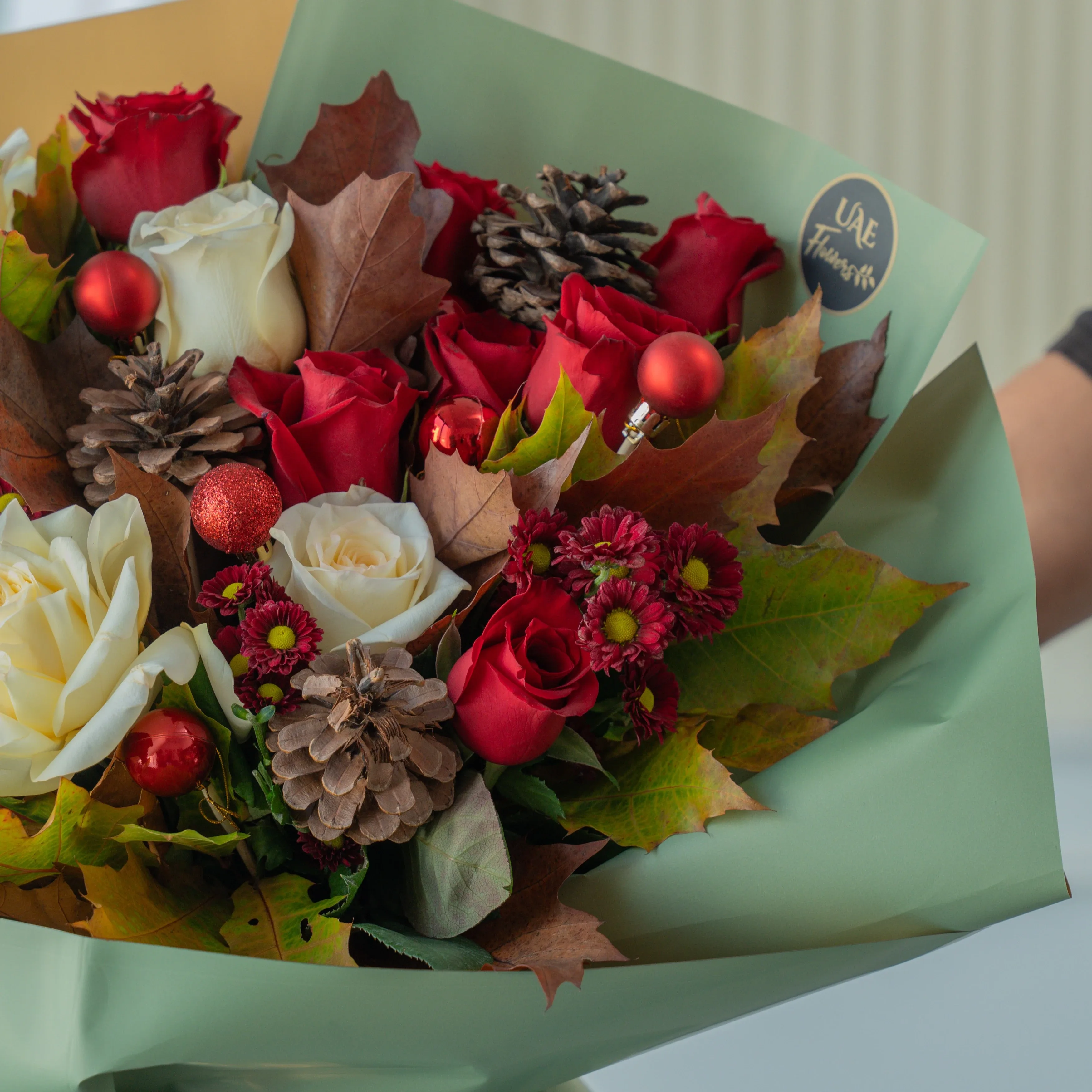 Festive red and white Christmas bouquet with pinecones and winter greens