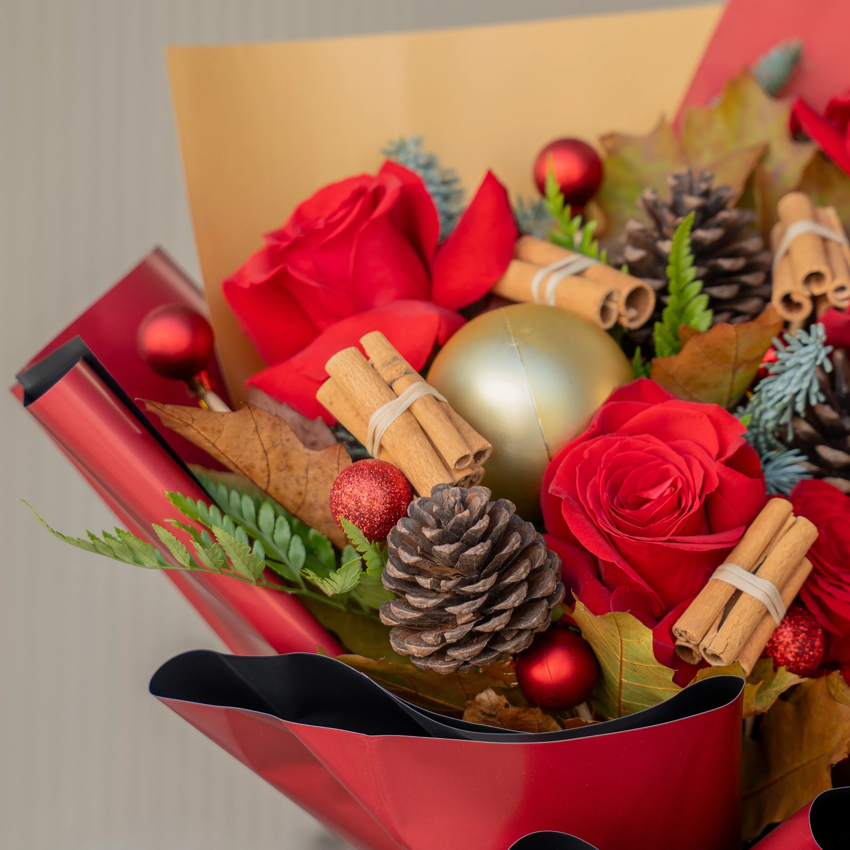 Festive red rose Christmas bouquet with pinecones and baubles