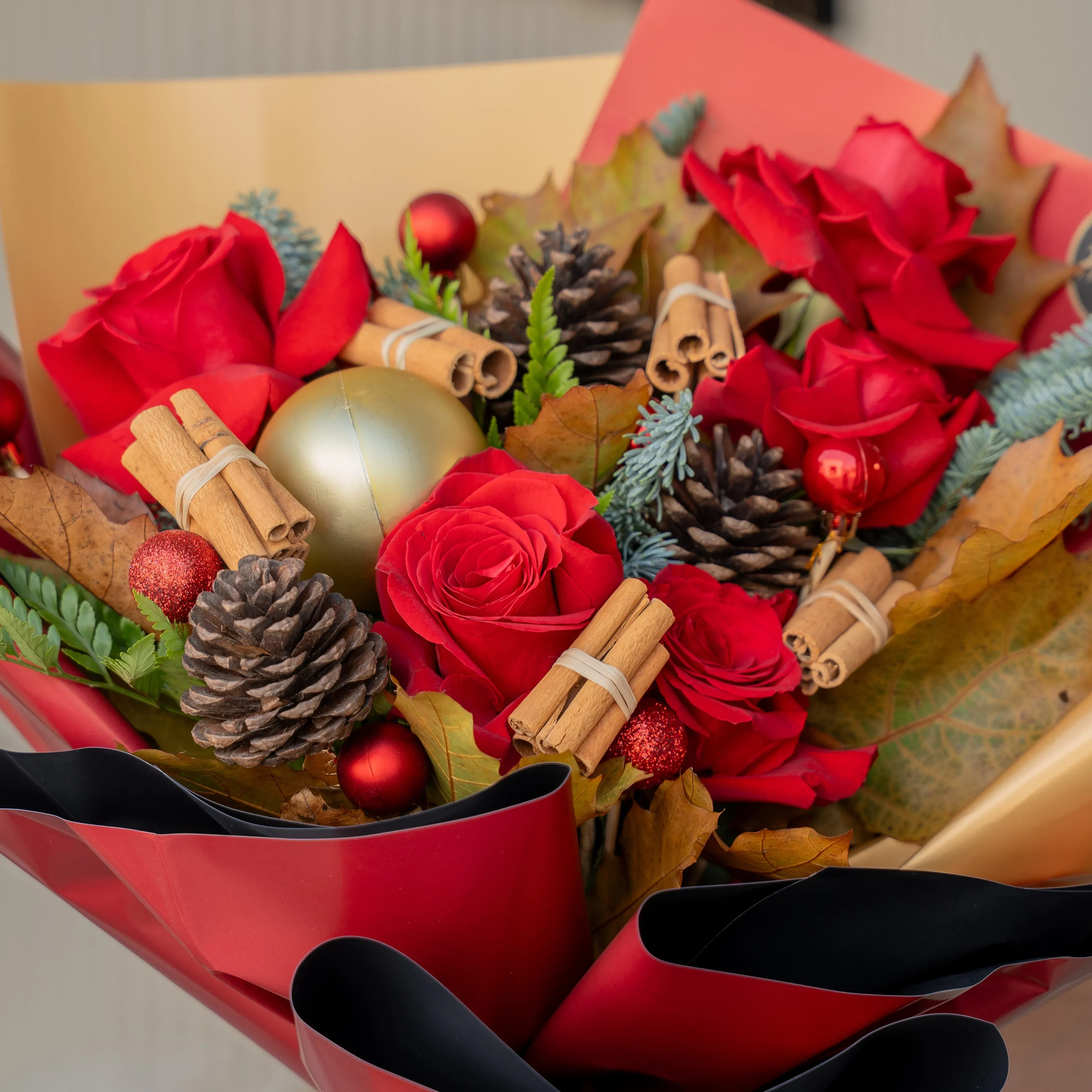 Festive red rose Christmas bouquet with pinecones and baubles