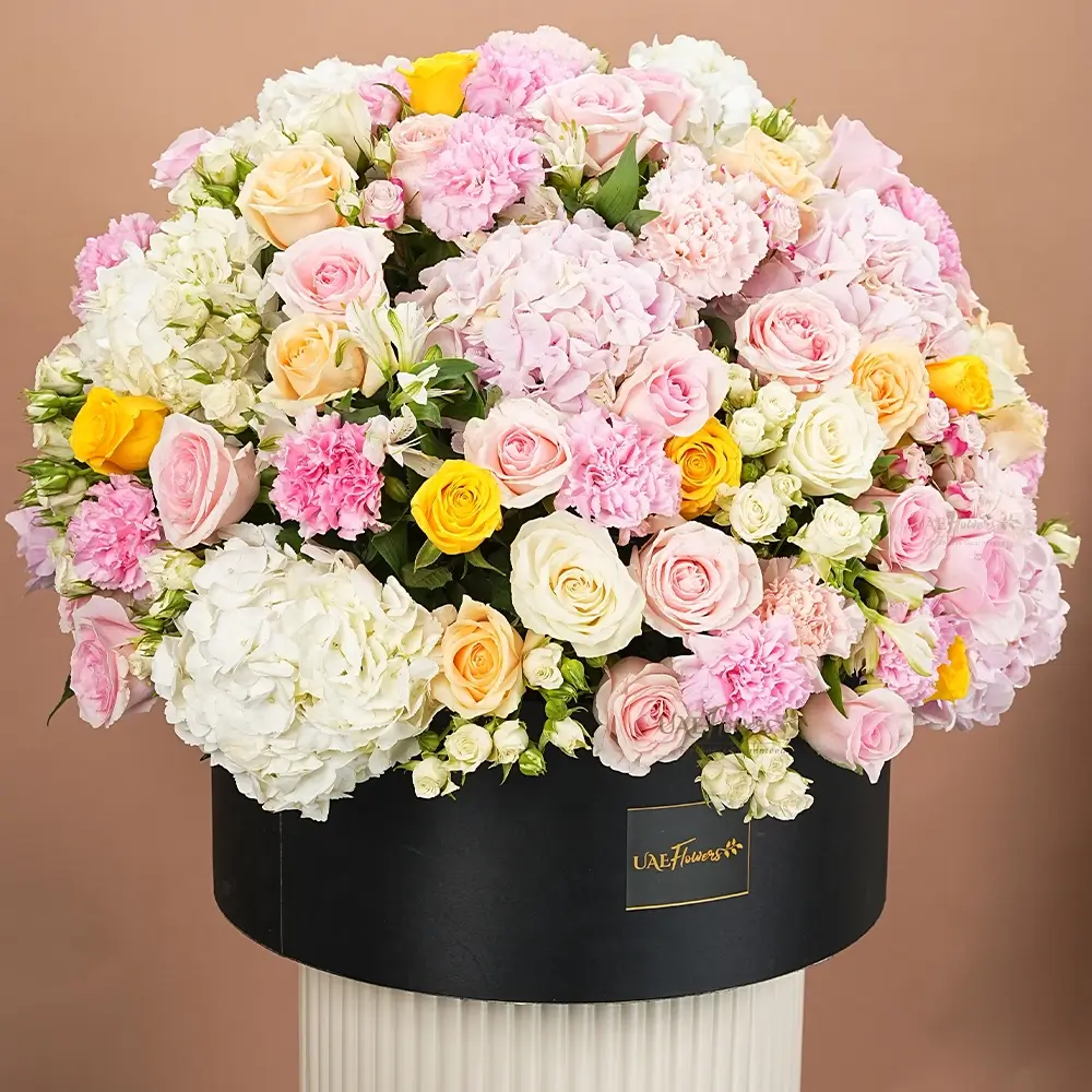 4 white and 4 pink hydrangeas, 20 pink carnations, 10 white roses, 10 yellow roses, 10 pink roses, 10 peach roses, 5 pink and white spray roses and 2 white alstroemeria with fillers in black round box