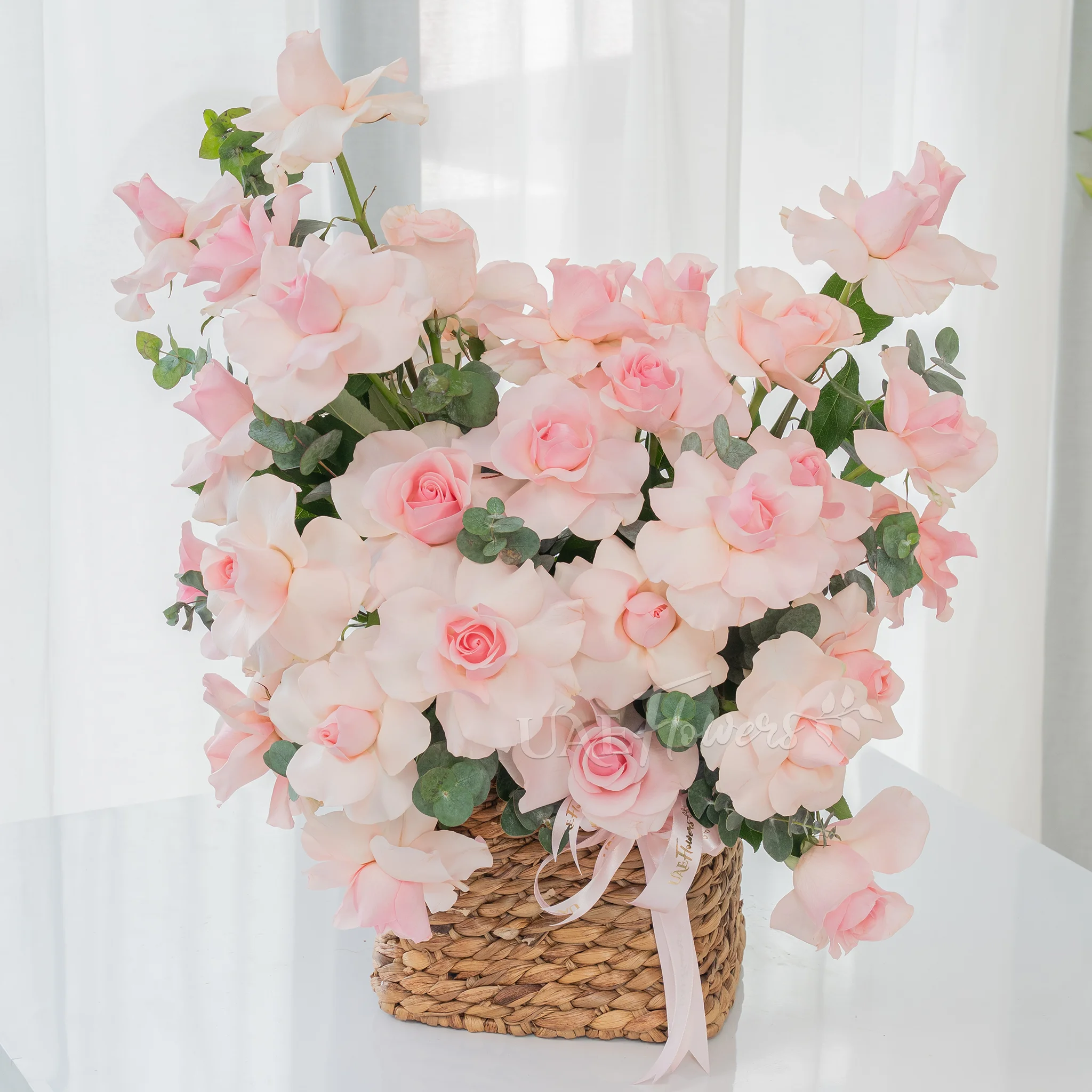 23 pink roses with green fillers in a basket.