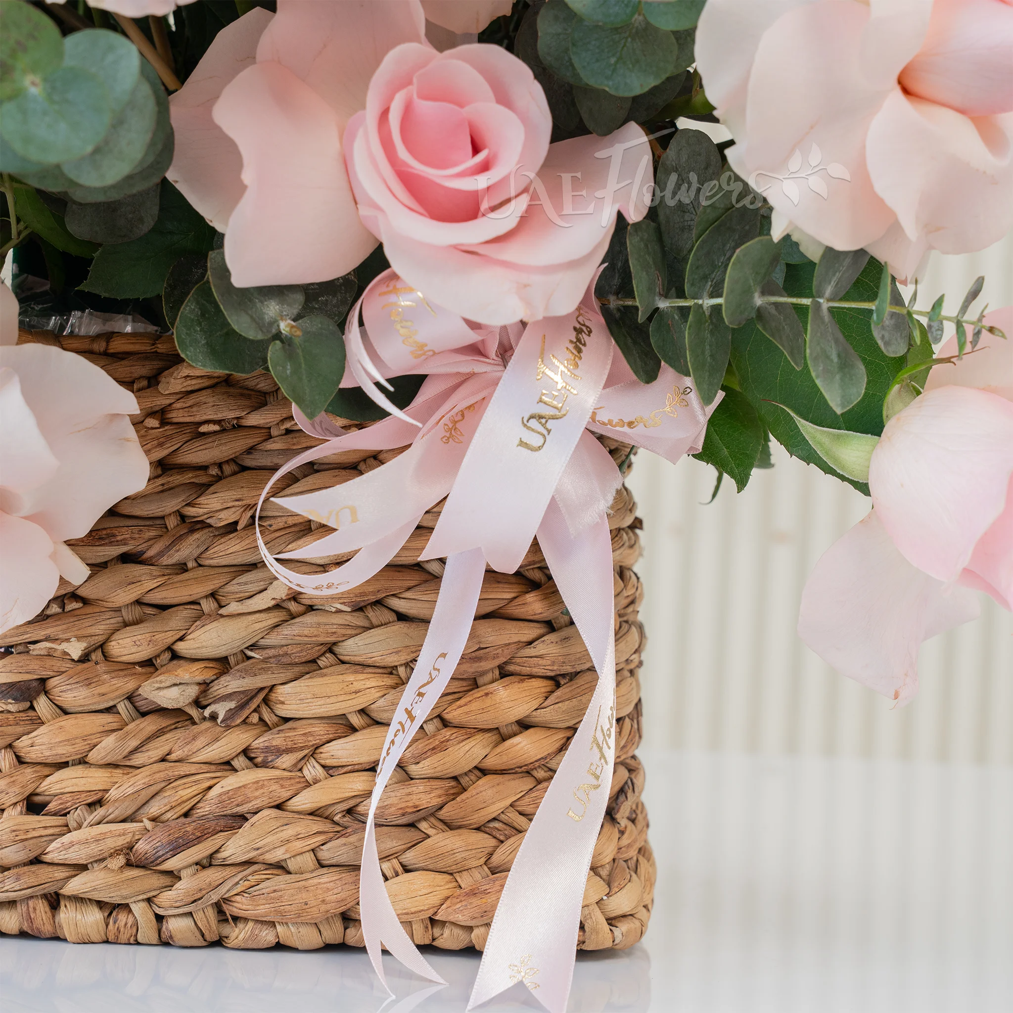 23 pink roses with green fillers in a basket.