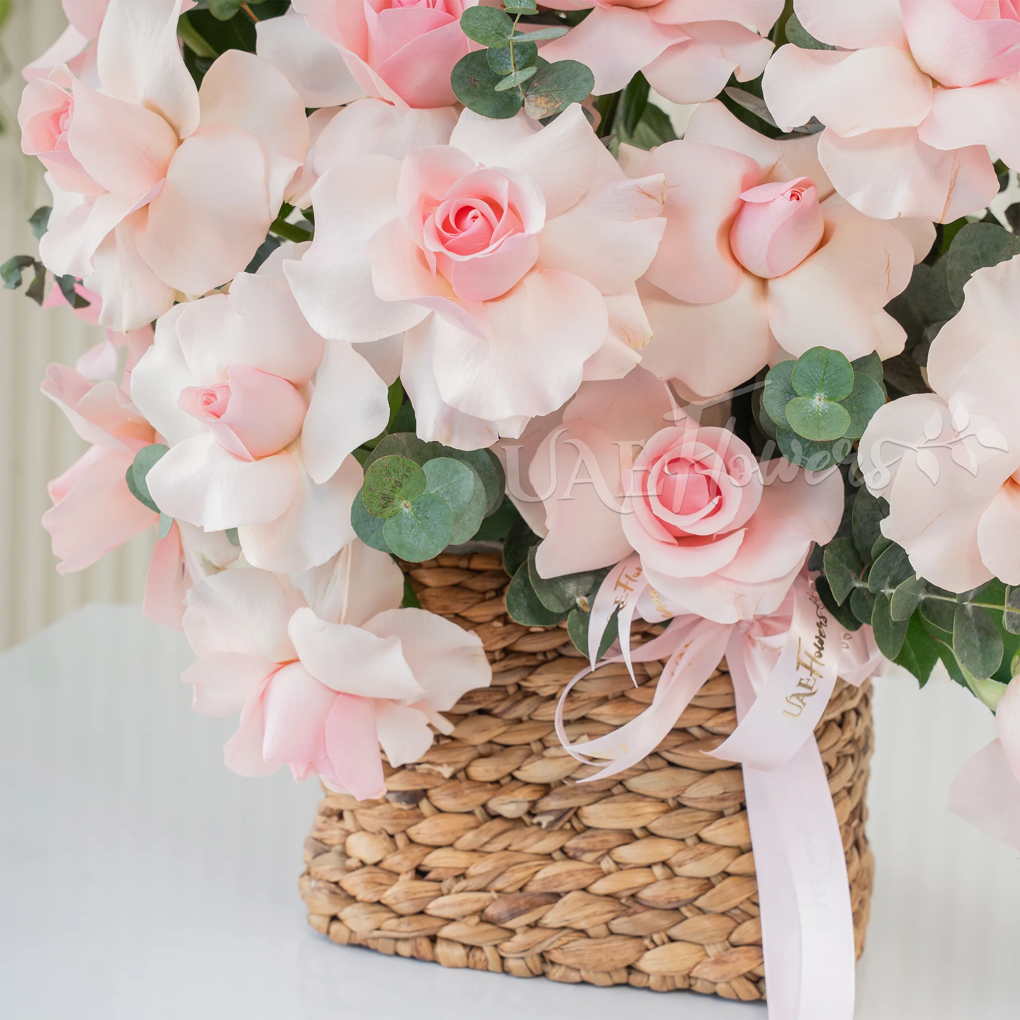 23 pink roses with green fillers in a basket.