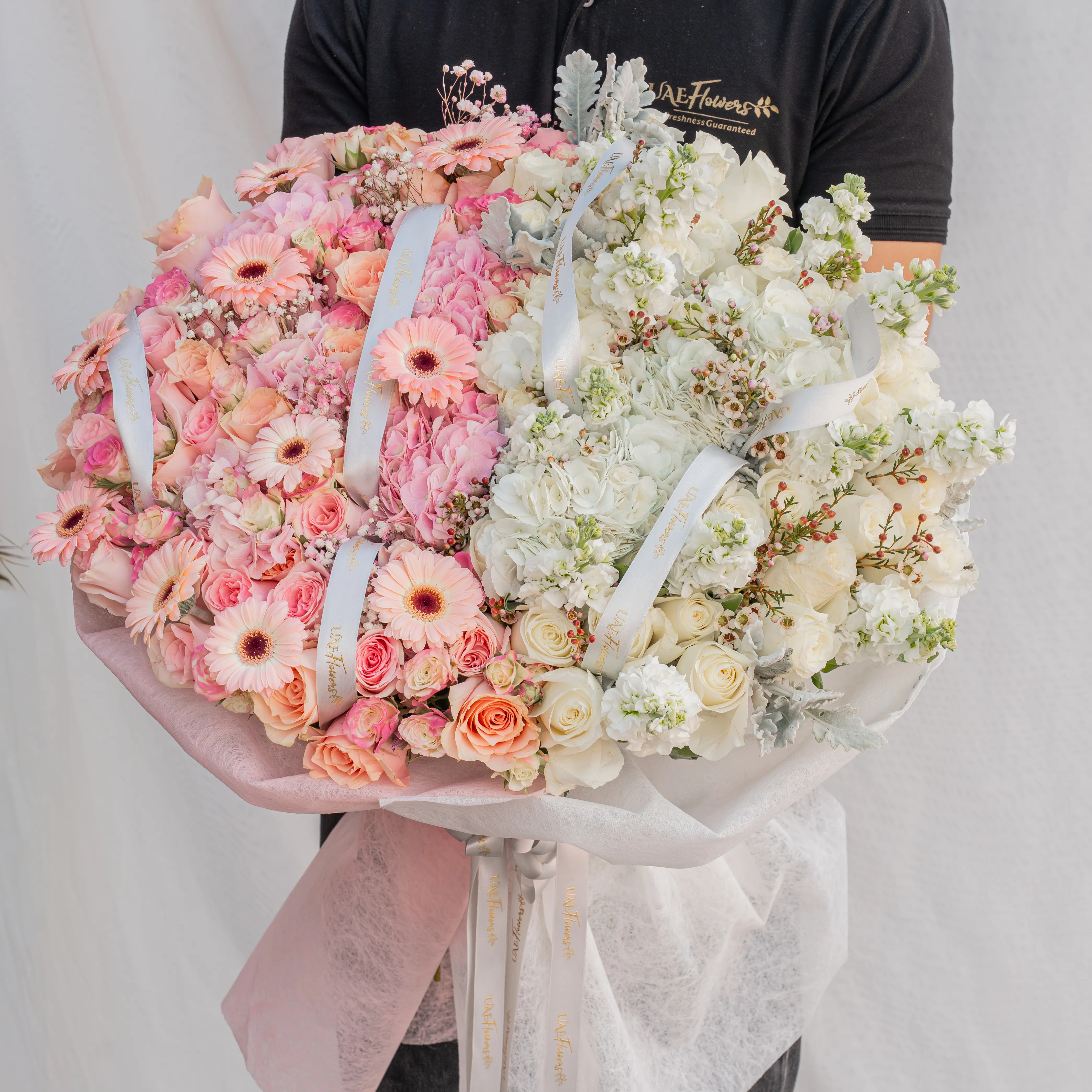 Bouquet of 4 pink hydrangeas, 30 pink roses, 10 pink spray roses, 10 pink gerberas, 3 white hydrangeas, 7 white matthiola and 30 white roses with pink & white wrapping paper and ribbon.