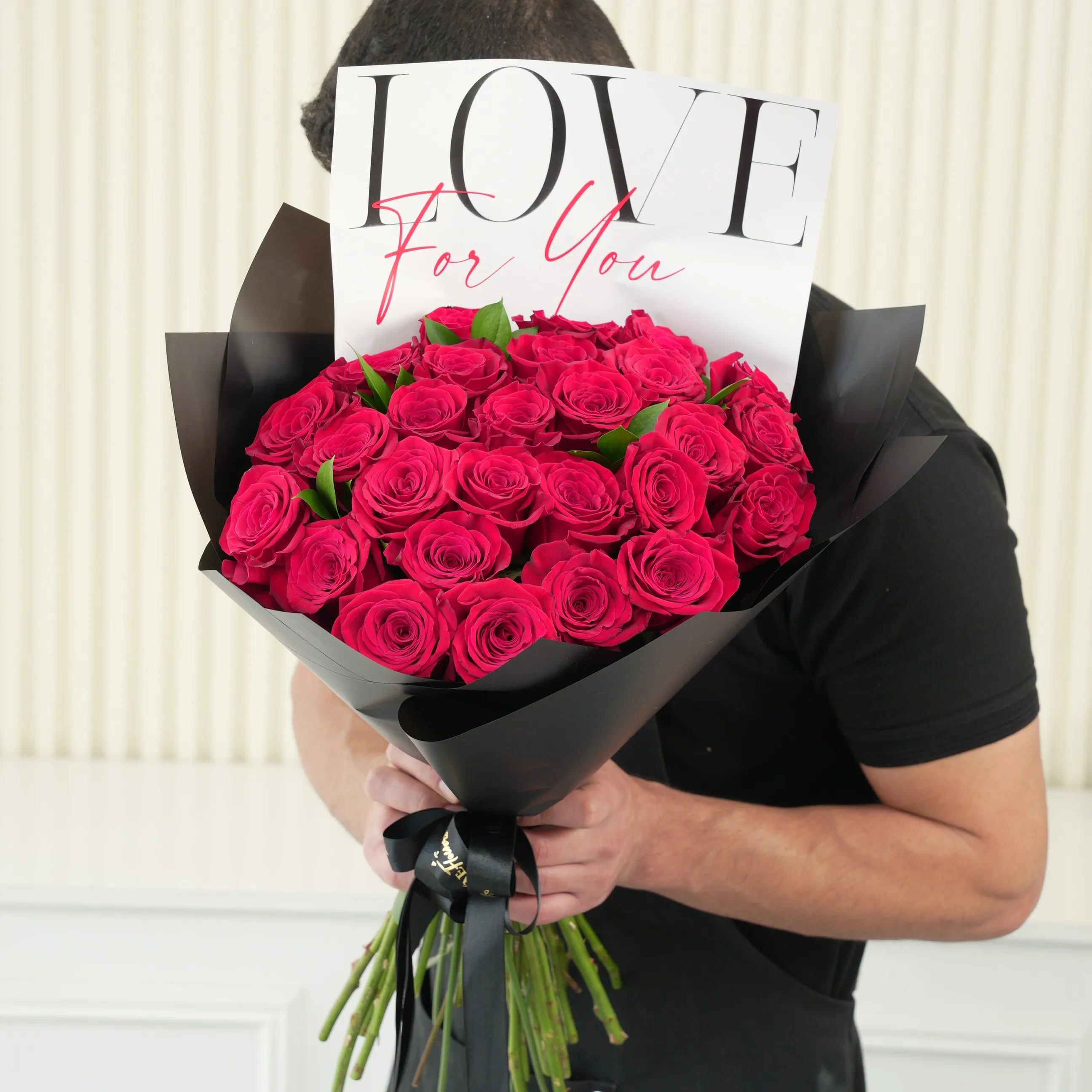 30 red roses with green fillers in black wrapping with Love For You Paper tied with black ribbons.