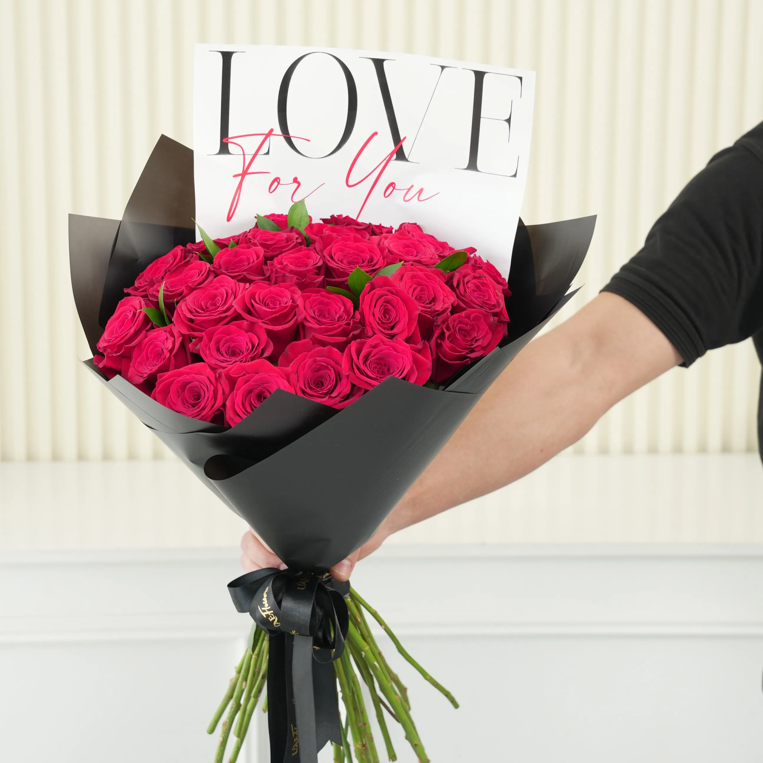 30 red roses with green fillers in black wrapping with Love For You Paper tied with black ribbons.