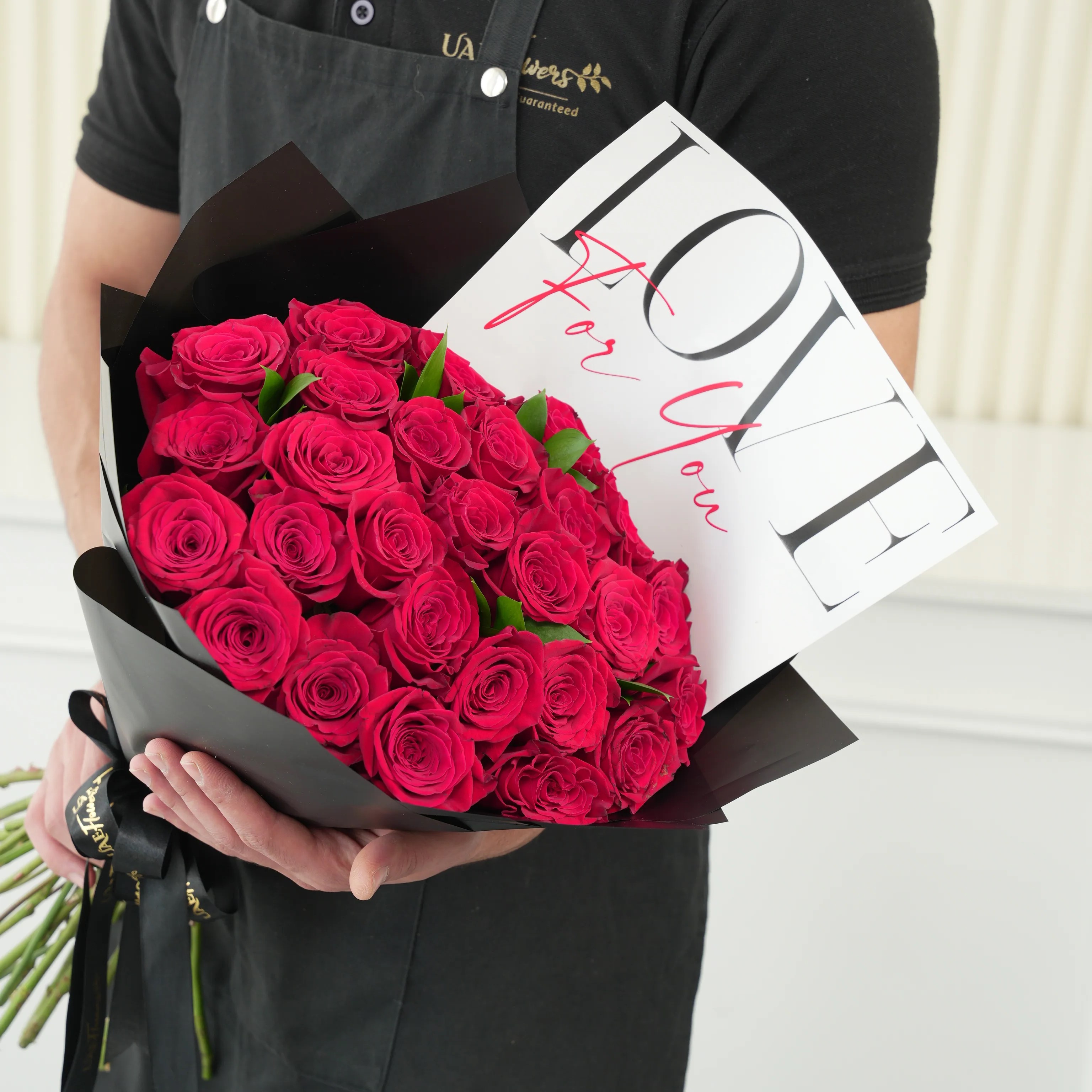 30 red roses with green fillers in black wrapping with Love For You Paper tied with black ribbons.