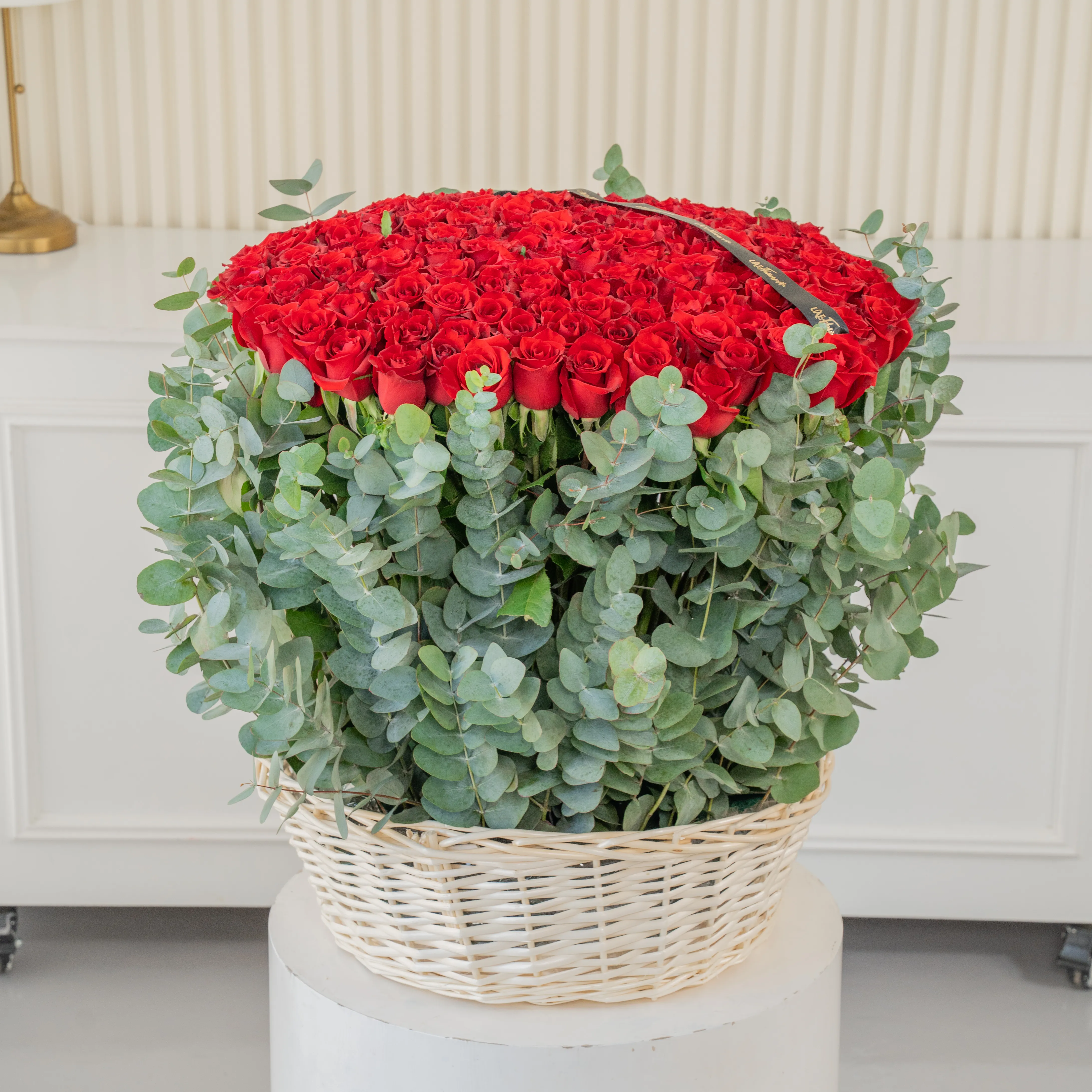 150 red roses with eucalyptus leaf in a basket.