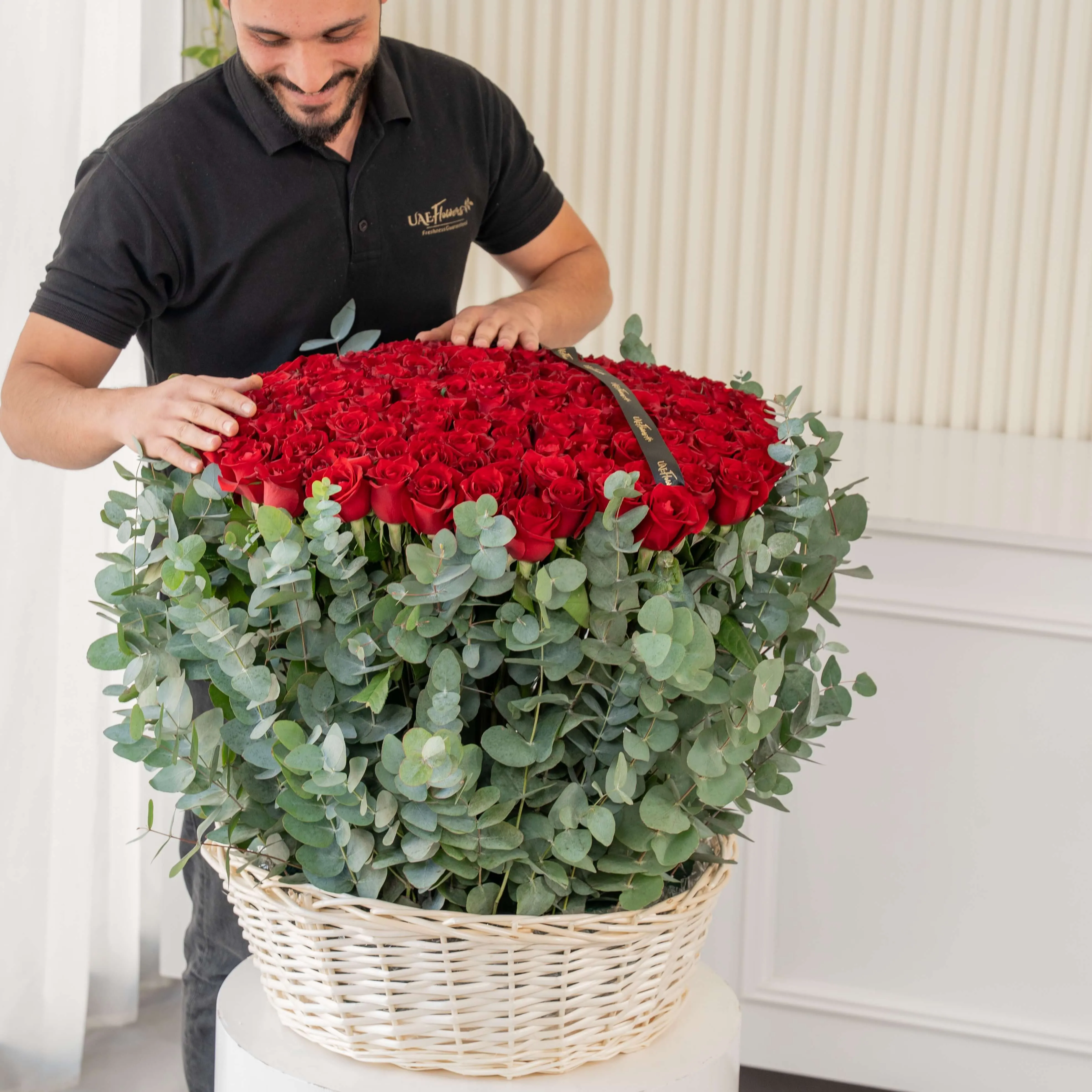 150 red roses with eucalyptus leaf in a basket.