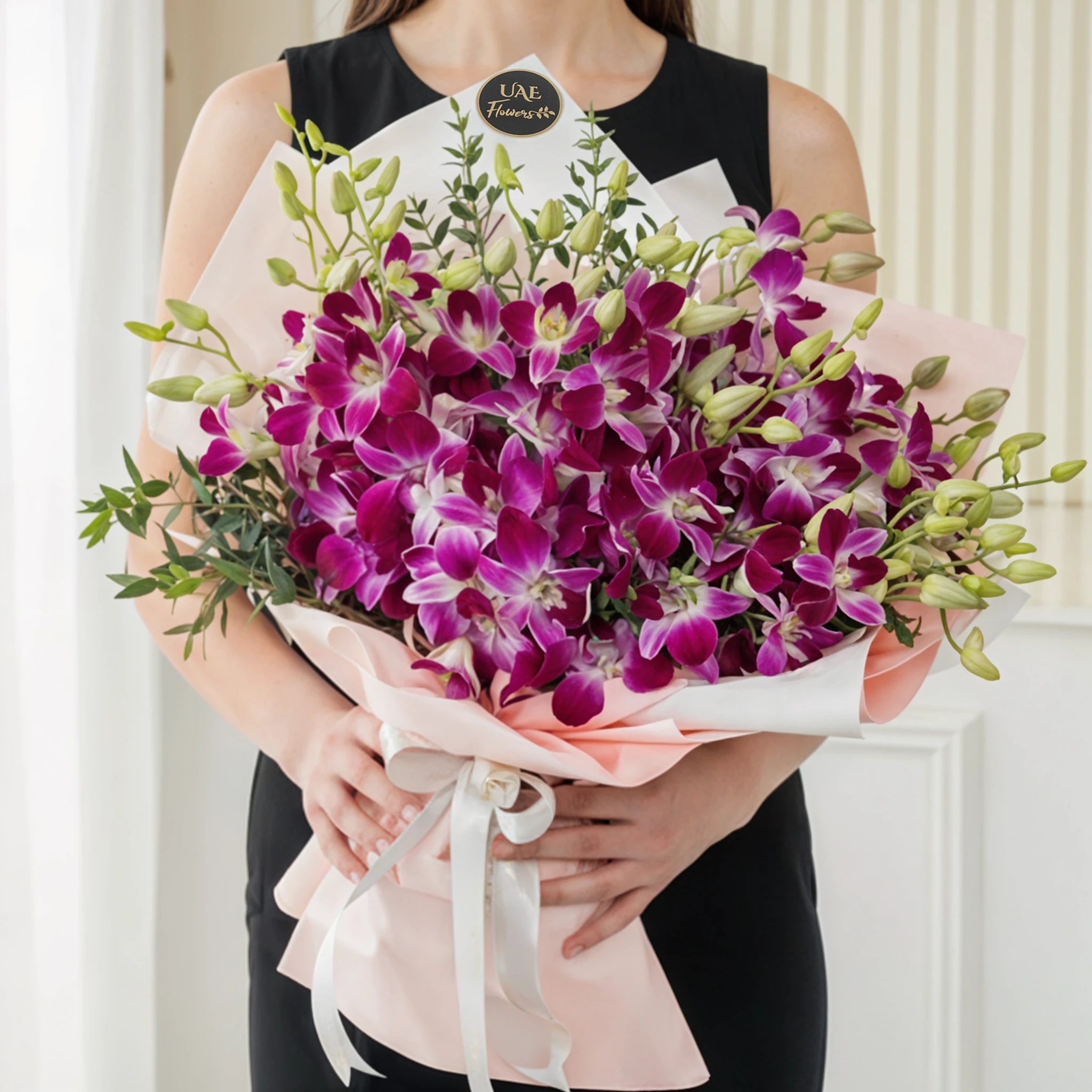 Bouquet of 20 purple orchids with fillers in a pink wrapping paper.