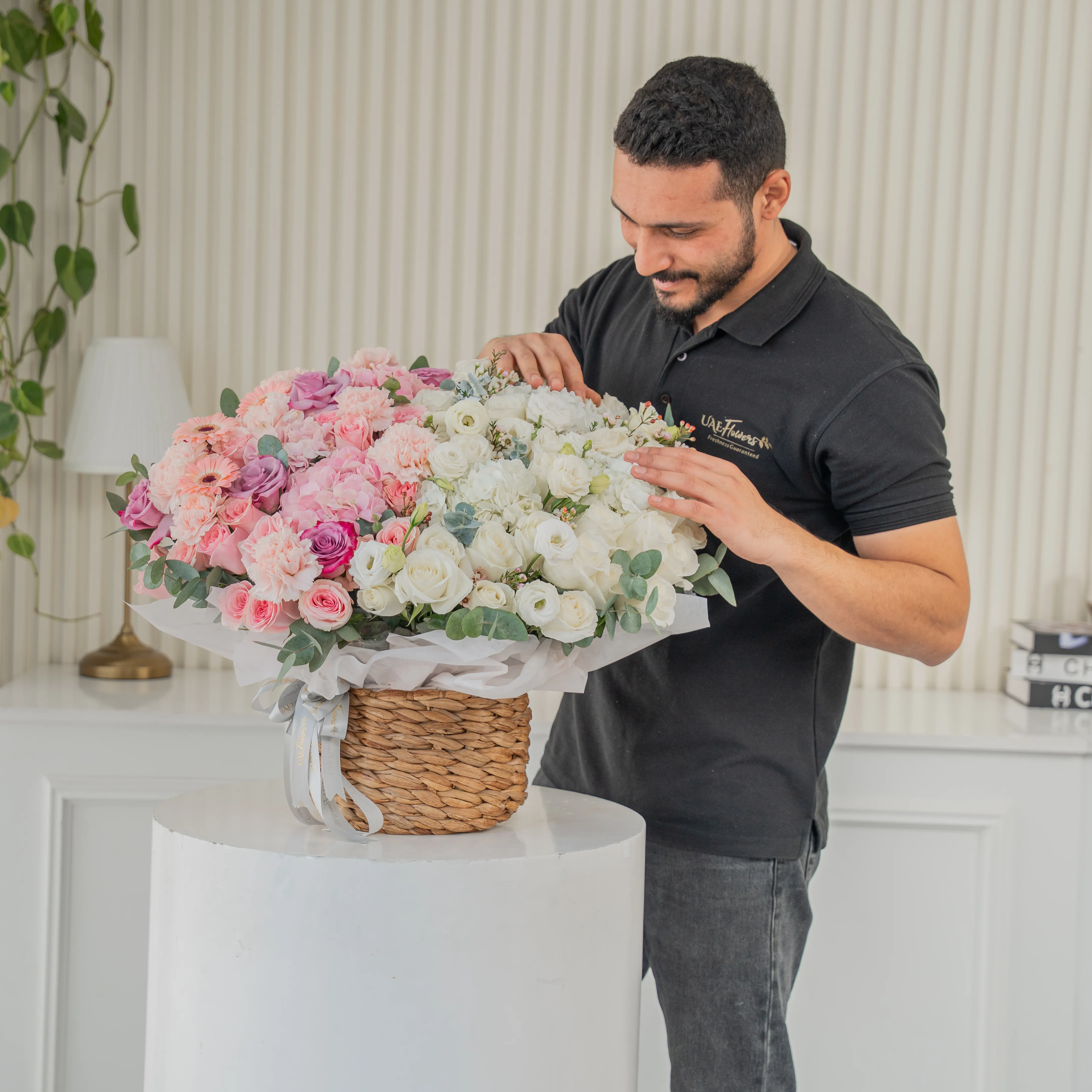 3 pink hydrangeas, 10 pink roses, 10 purple roses, 10 pink carnations, 3 pink gerberas, 3 white hydrangeas, 20 white roses and 7 white lisianthus with green fillers in a basket.