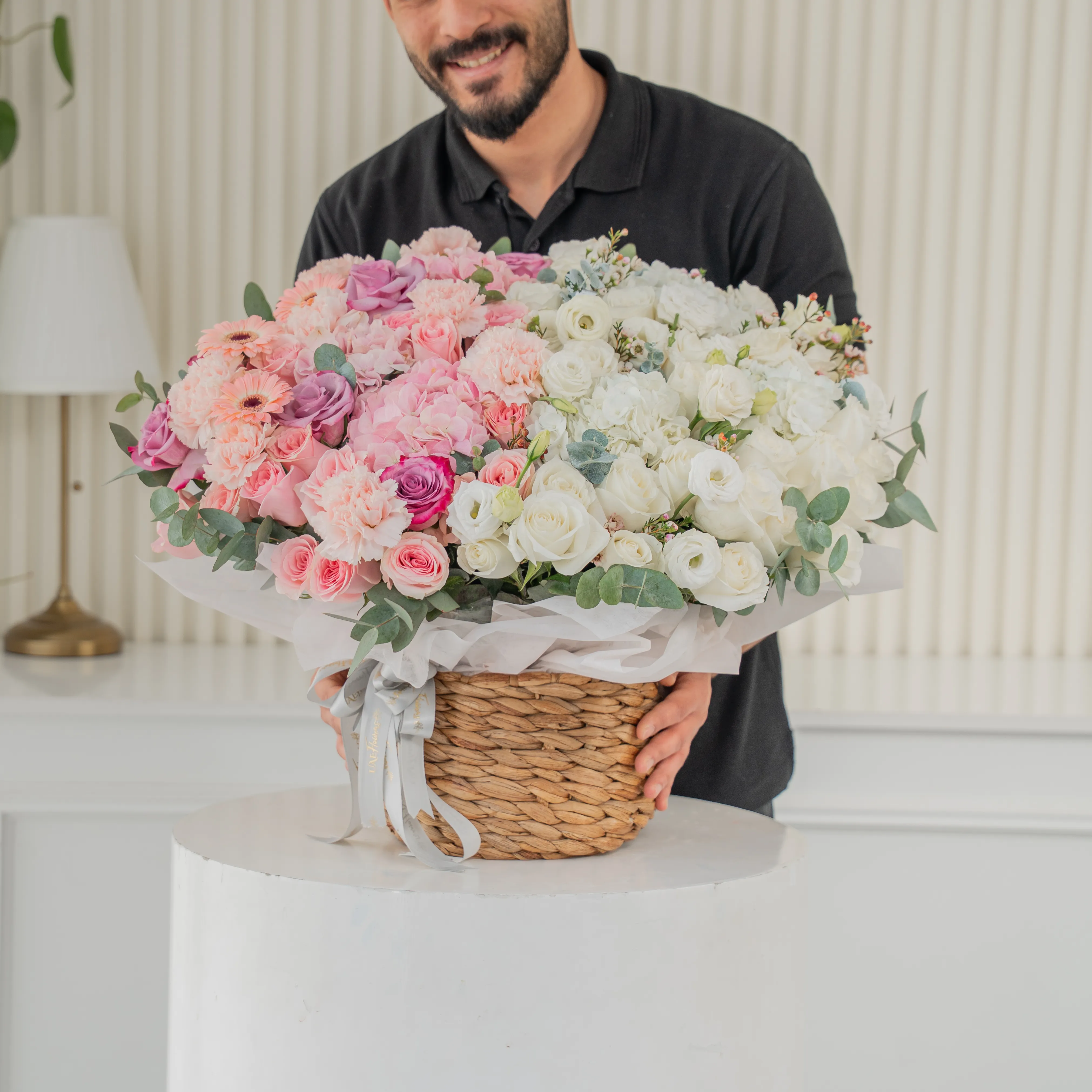 3 pink hydrangeas, 10 pink roses, 10 purple roses, 10 pink carnations, 3 pink gerberas, 3 white hydrangeas, 20 white roses and 7 white lisianthus with green fillers in a basket.