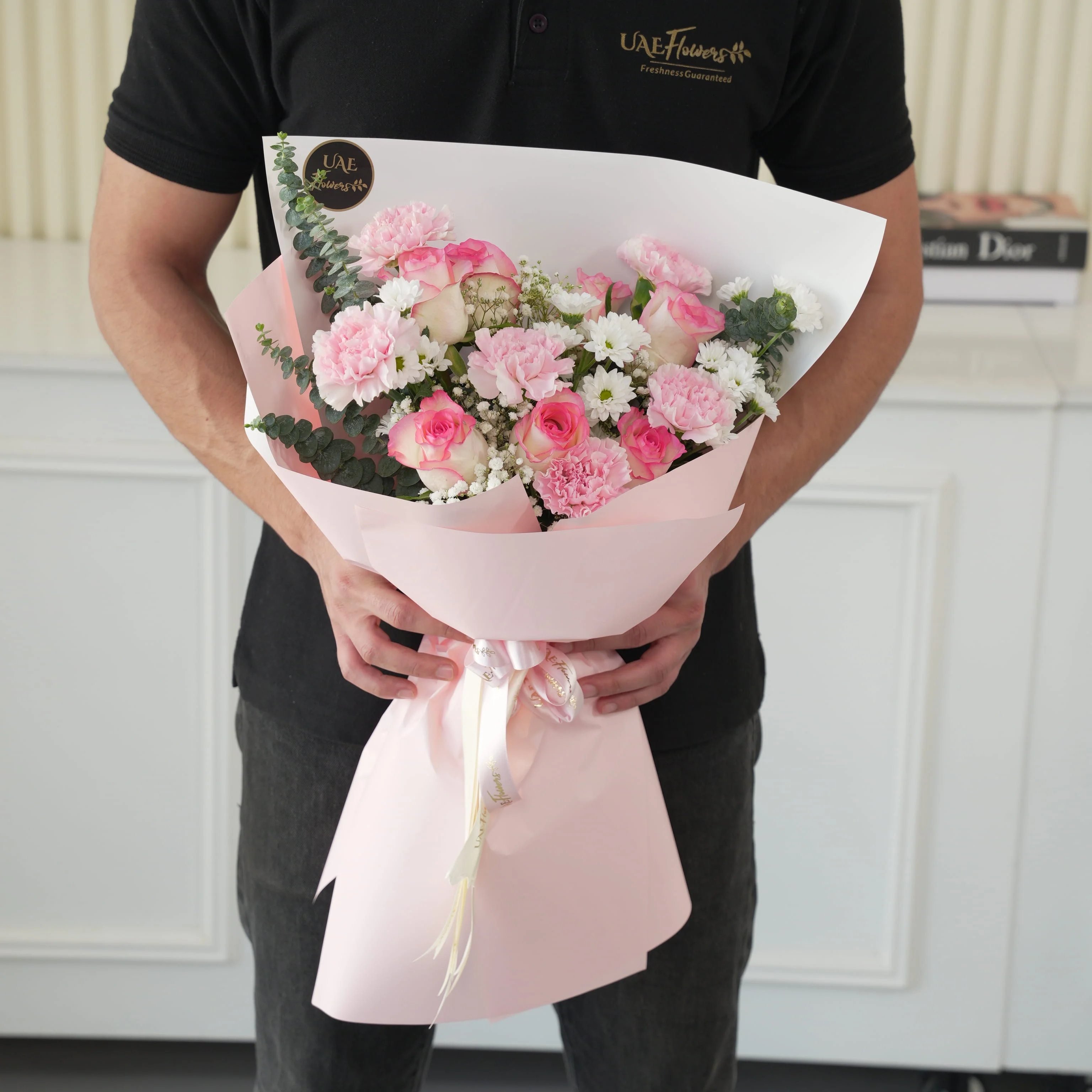 Bouquet of 6 pink roses, 6 pink carnations, 3 pink spray carnations with green fillers in pink wrapping.