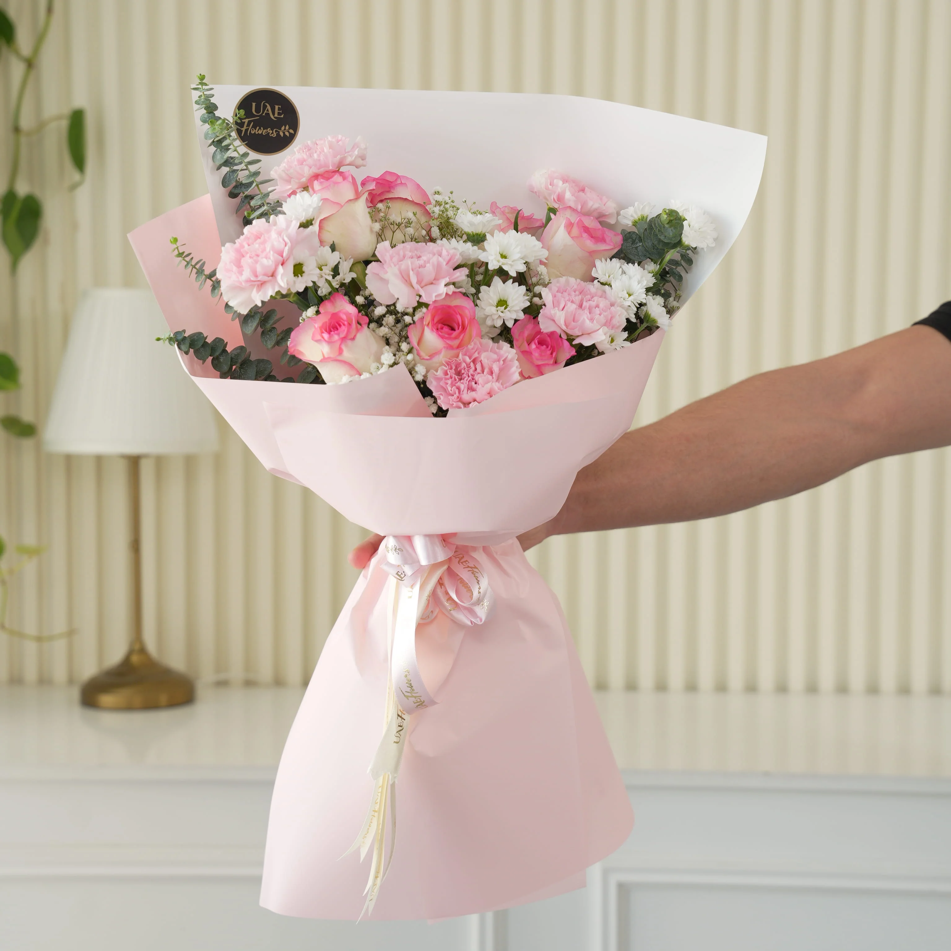 Bouquet of 6 pink roses, 6 pink carnations, 3 pink spray carnations with green fillers in pink wrapping.