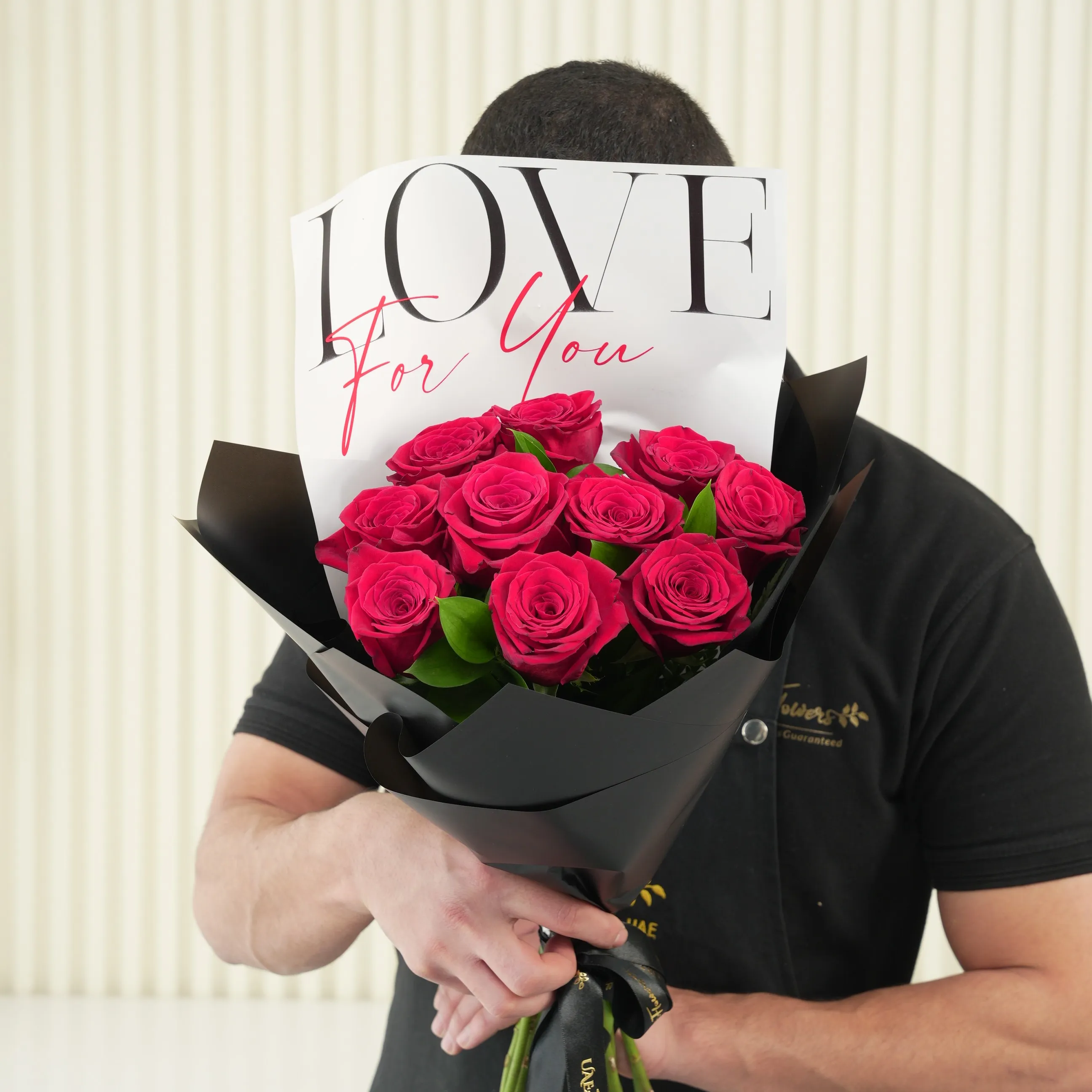 10 red roses with green fillers in black wrapping with Love For You Paper tied with black ribbons.