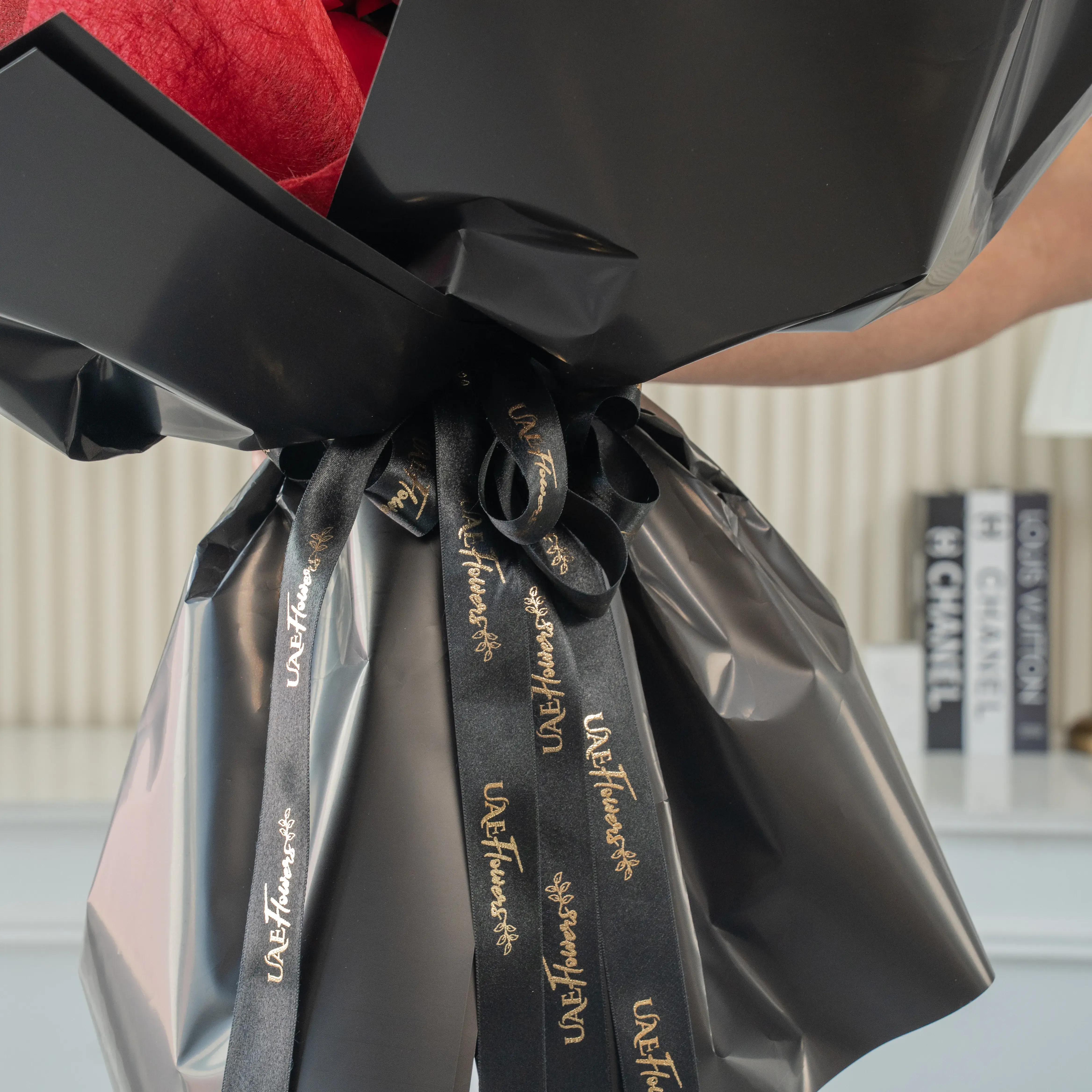 Bouquet of 8 red roses, 2 red spray roses, red alstroemeria with eucalyptus leaf in black paper packing.