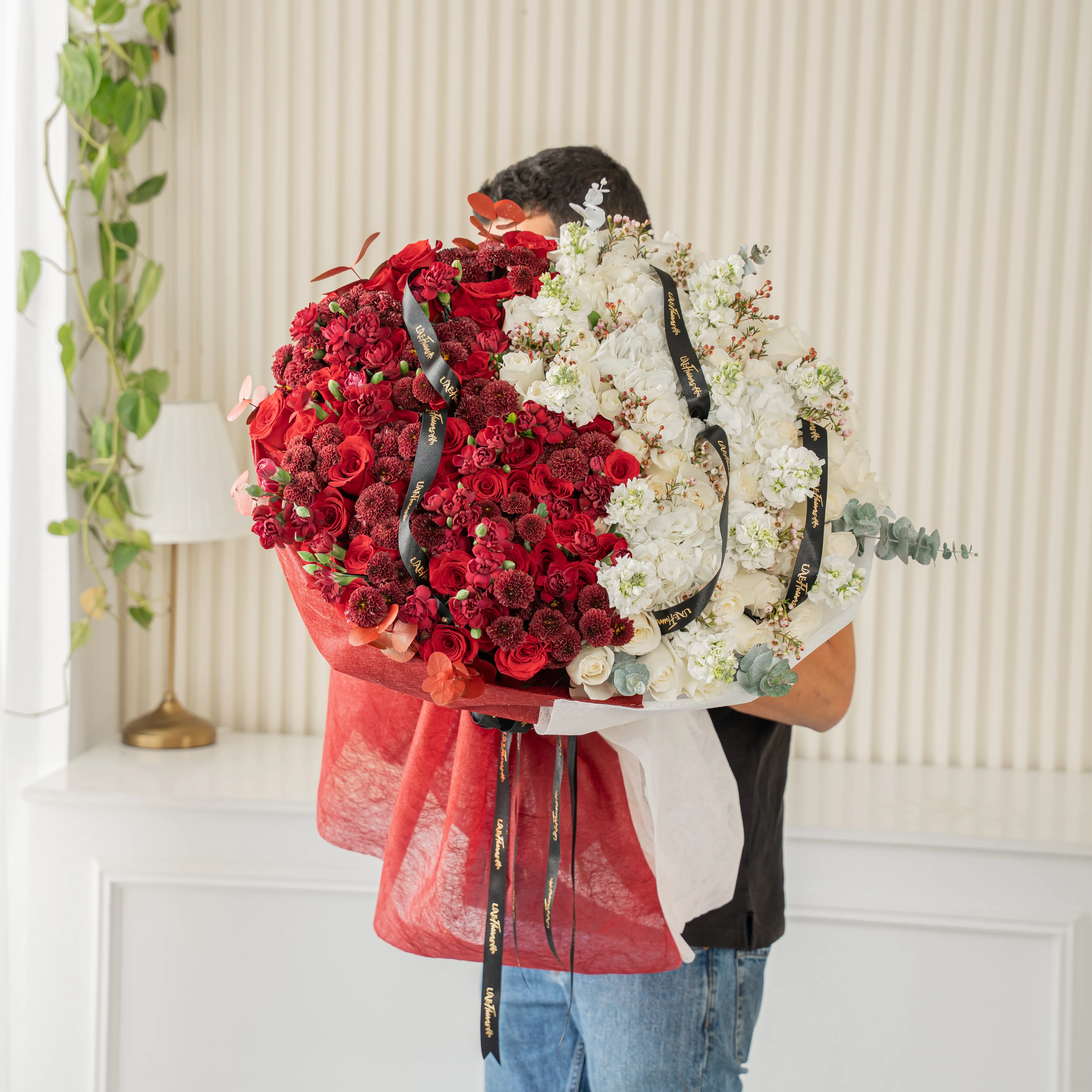 Bouquet of 25 red roses, 15 red chrysanthemums, 10 red spray carnations, 3 white hydrangeas, 25 white roses and 10 white matthiola with eucalyptus leaf in red and white wrapping paper tied with ribbon.