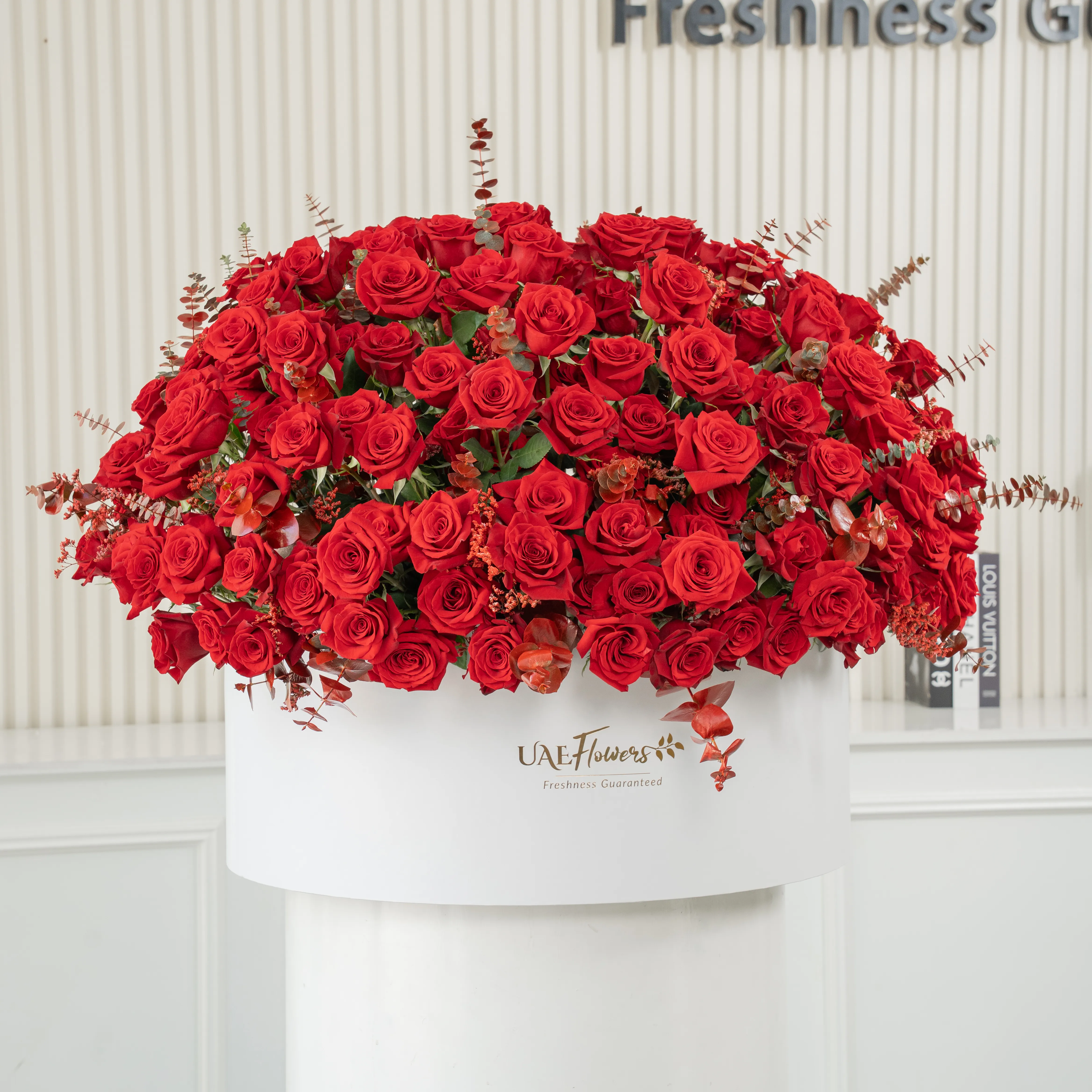 Full round arrangement of 250 red roses in a white round box.