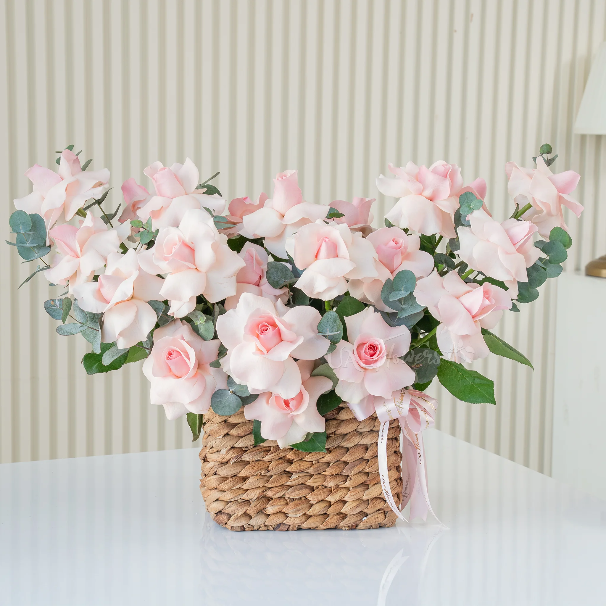 basket of blooming pink roses with lush green fillers
