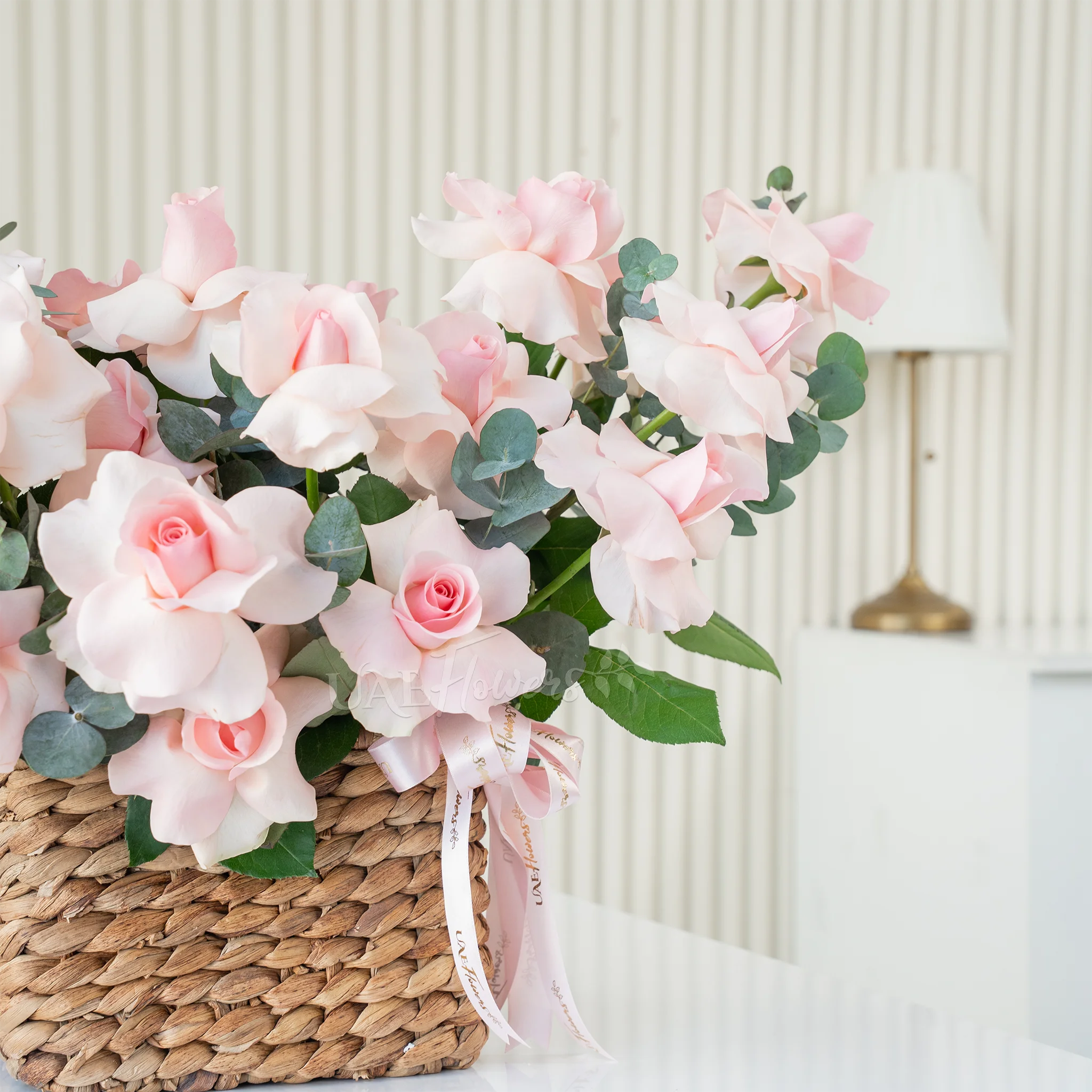 basket of blooming pink roses with lush green fillers