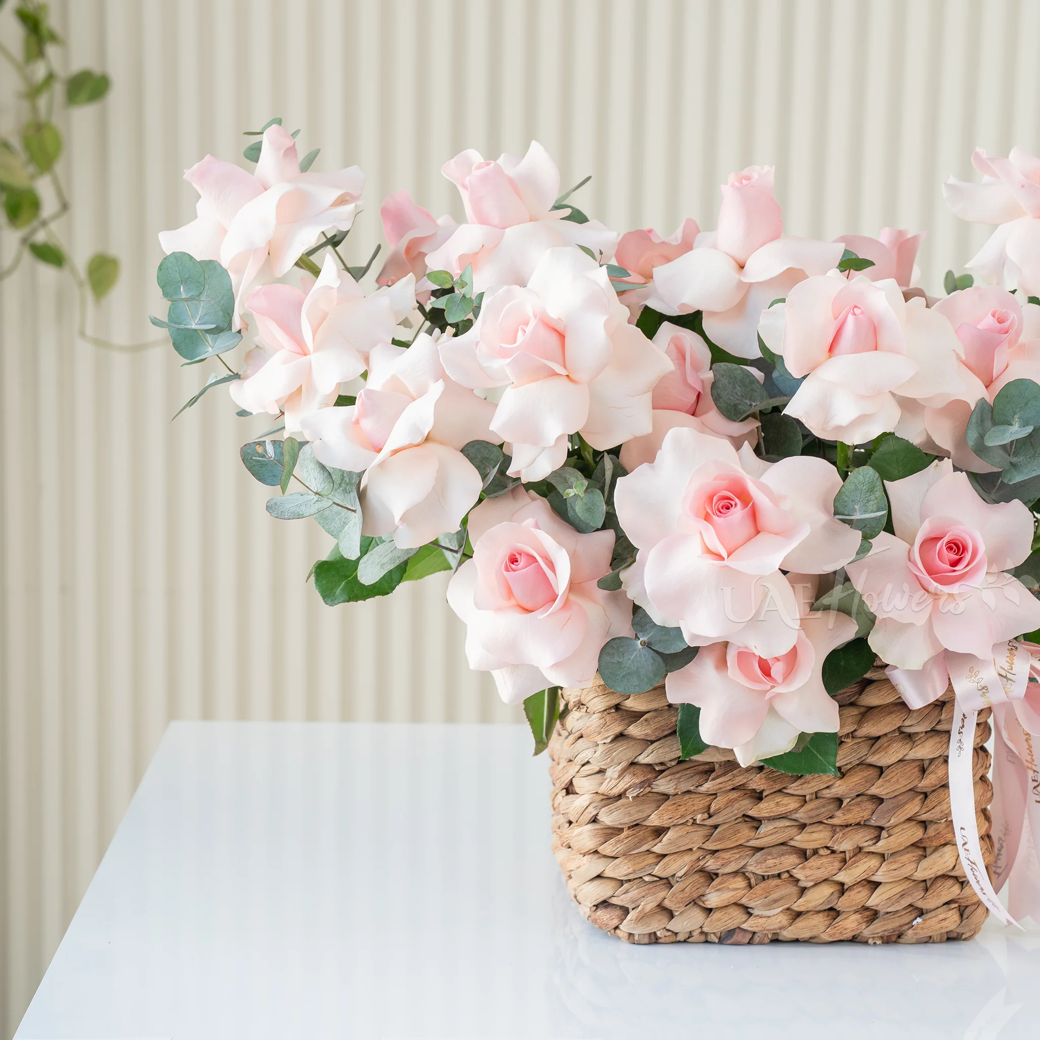 basket of blooming pink roses with lush green fillers
