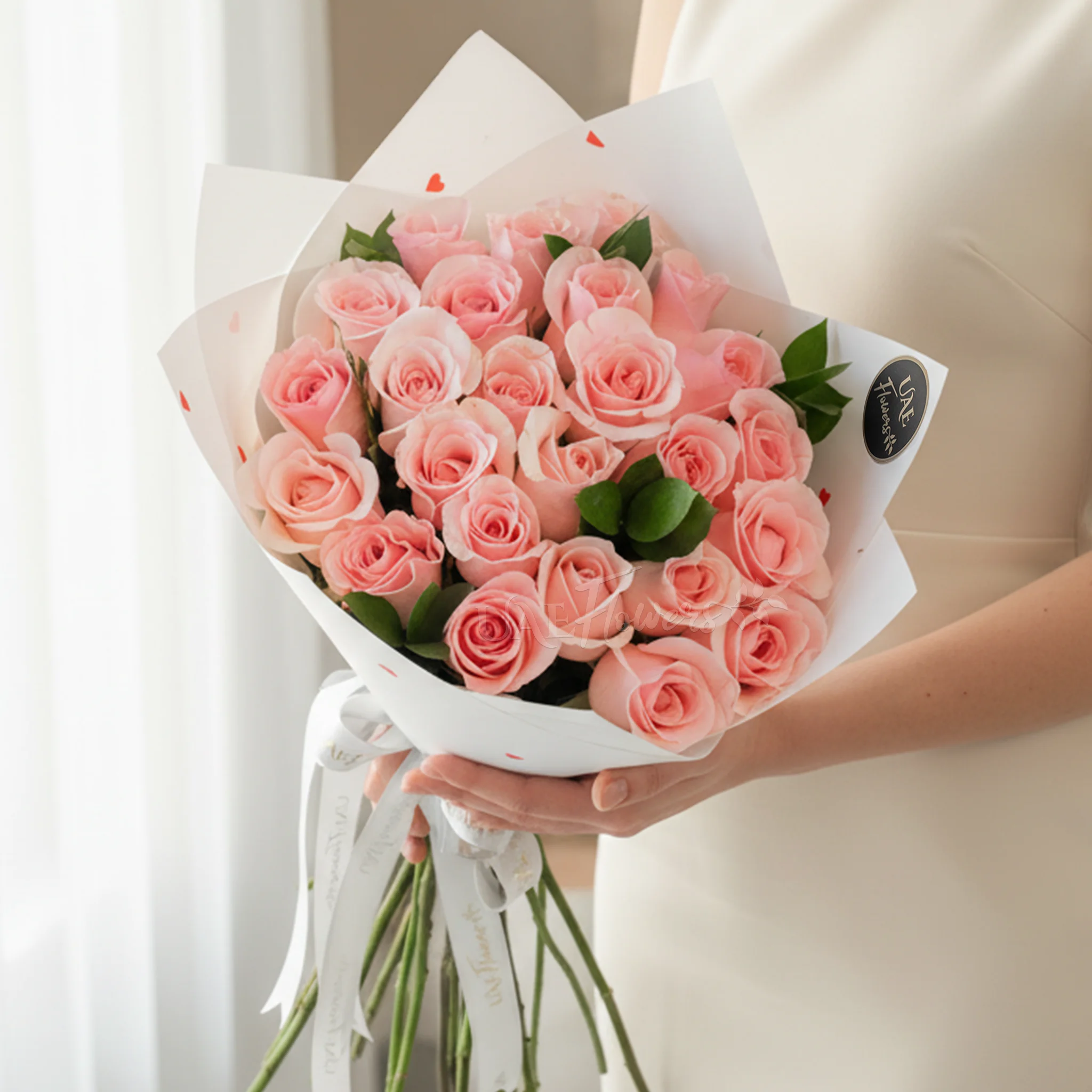Bouquet of 20 pink roses in paper packing hand-tied with ribbons.