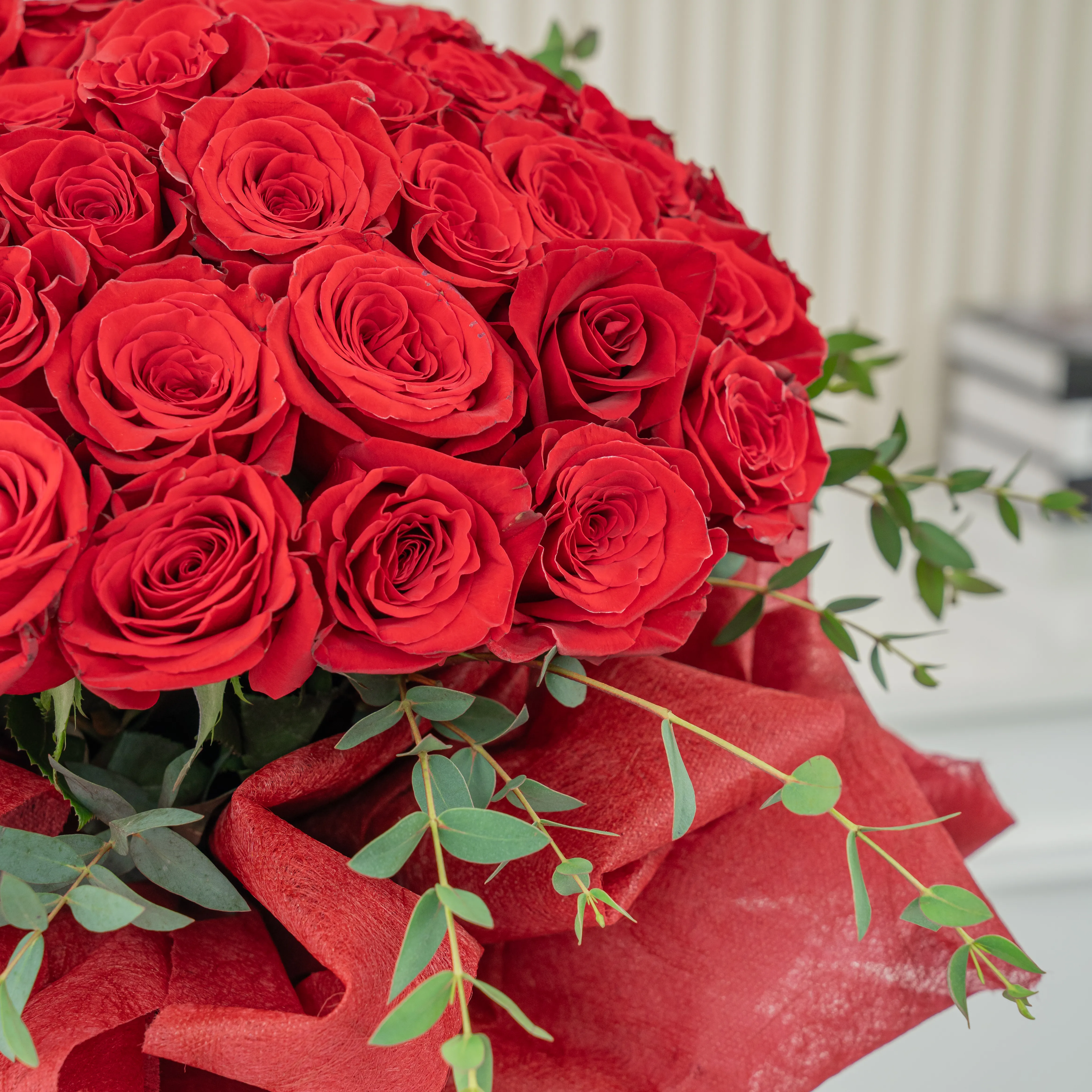 Bouquet of 40 Red Roses with green fillers in red wrapping.