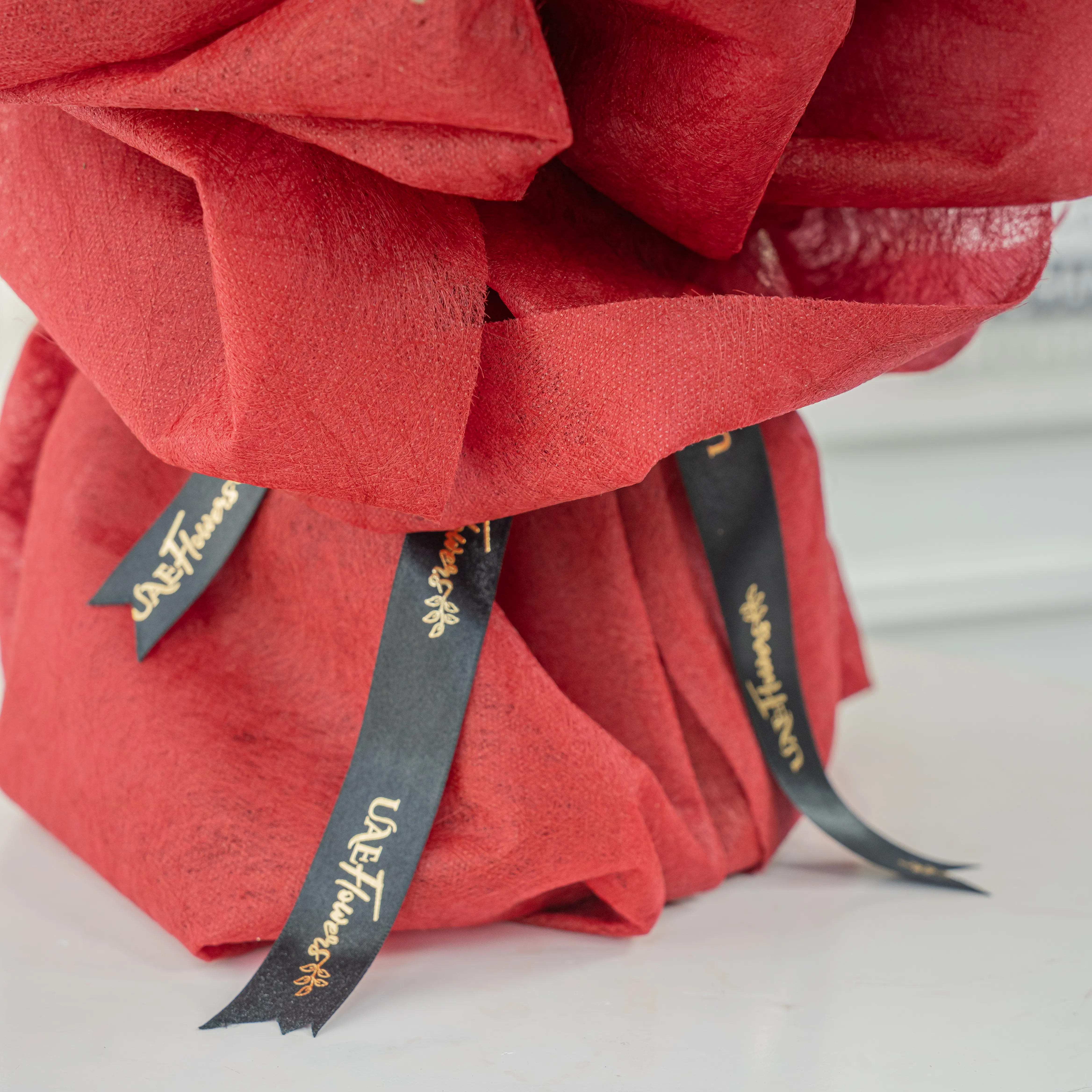 Bouquet of 40 Red Roses with green fillers in red wrapping.