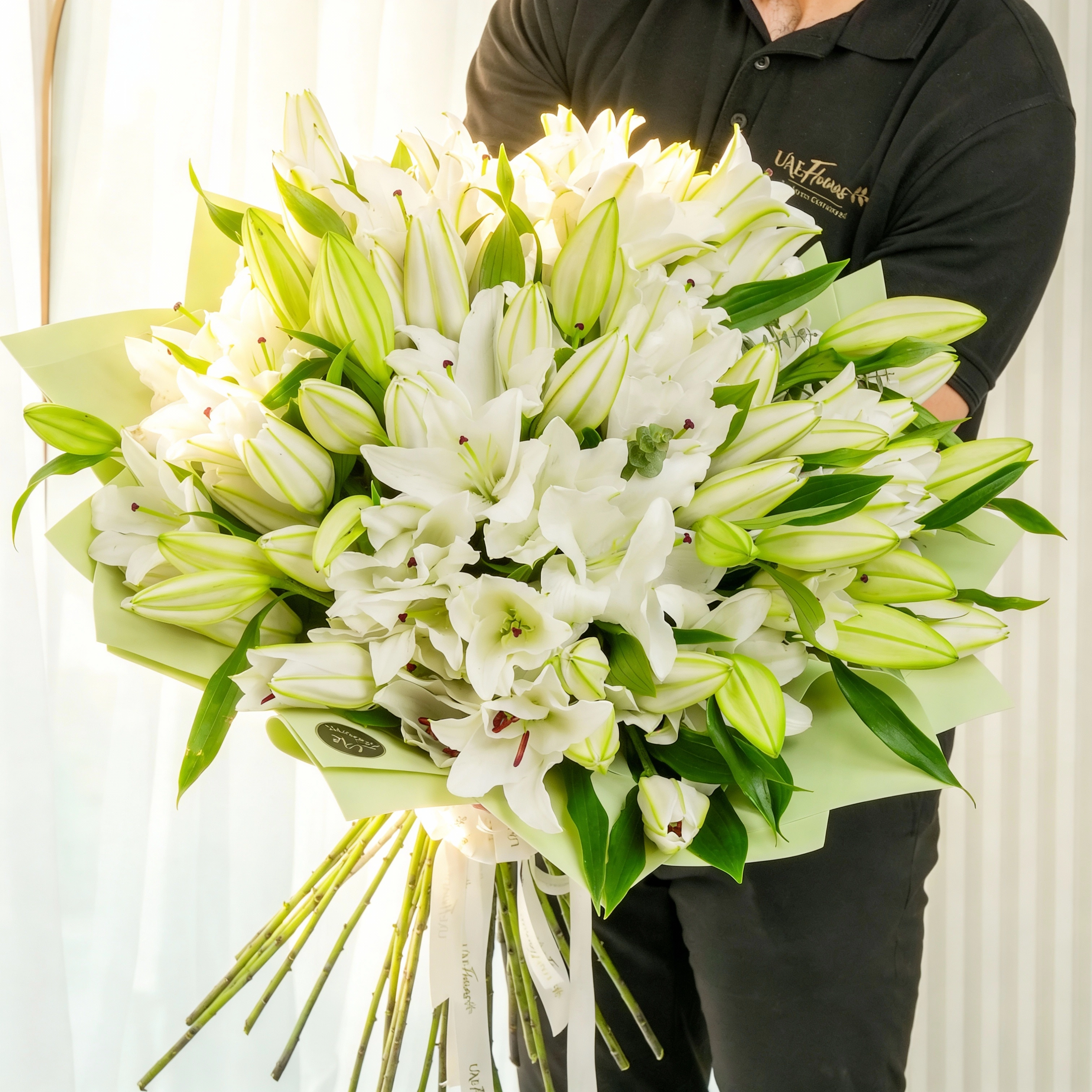 bouquet of 20 white lilies with green fillers wrapped in pastel green paper