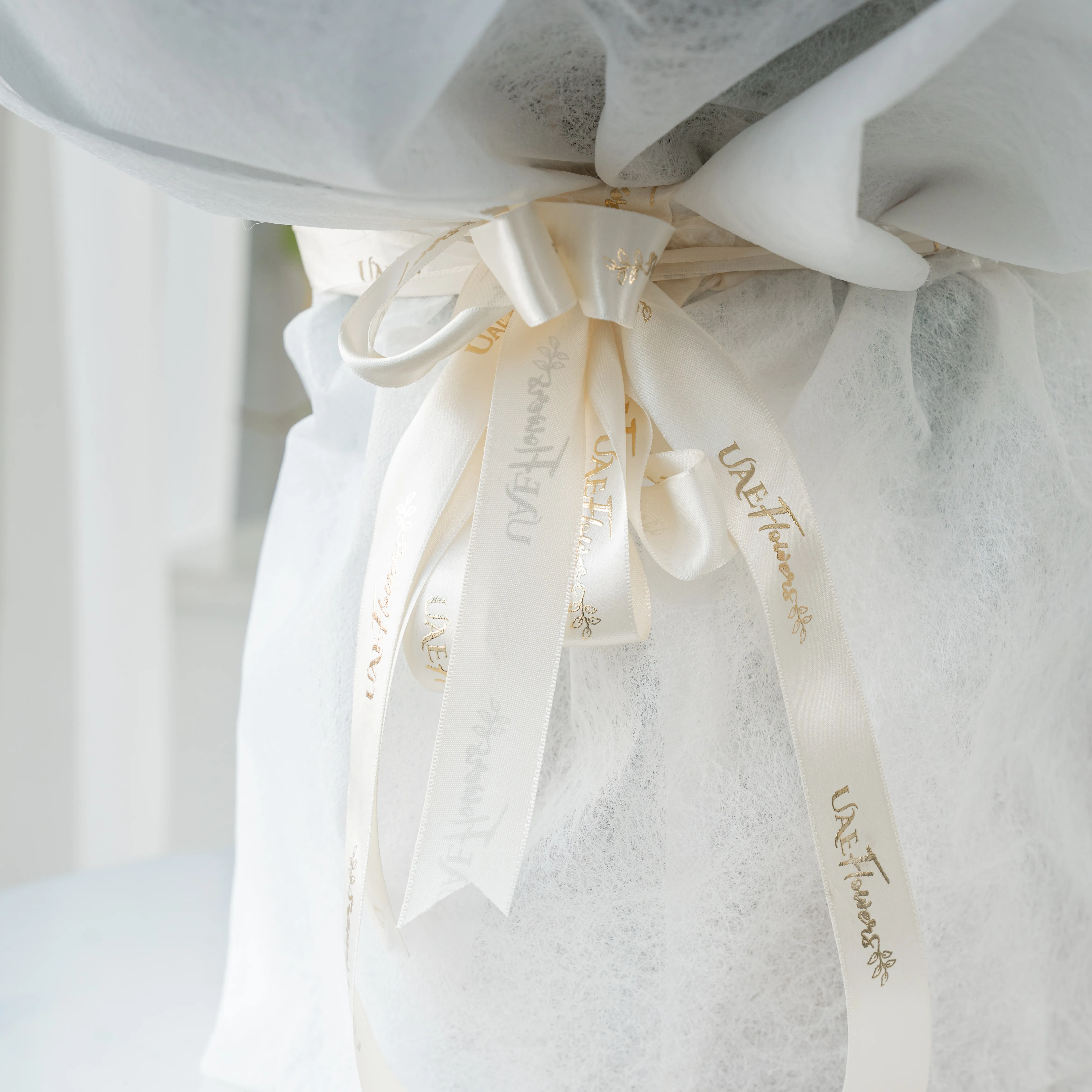 Bouquet of 20 white roses, 12 purple roses and 5 carnations with eucalyptus leaf and green fillers in white paper packing tied with white ribbon.