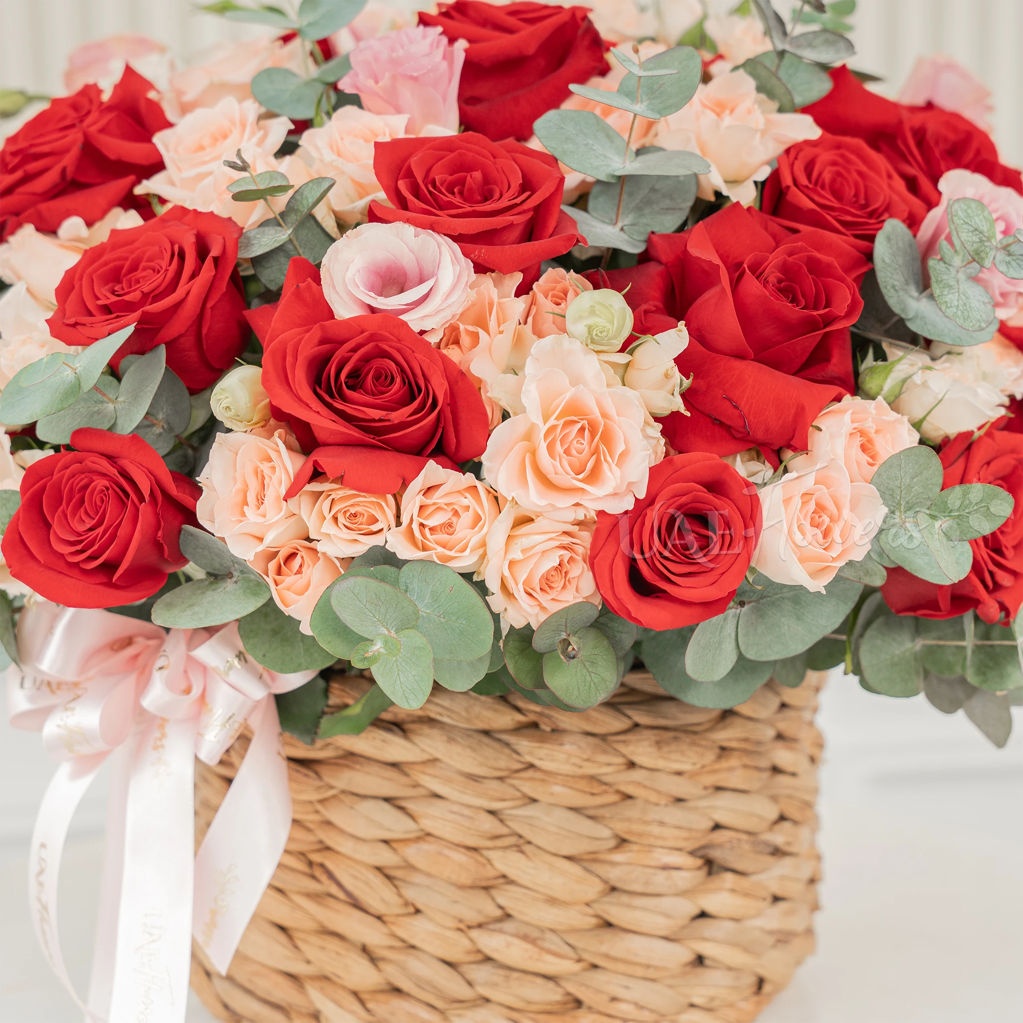 22 red roses and 12 pink spray roses with fillers in a round basket.