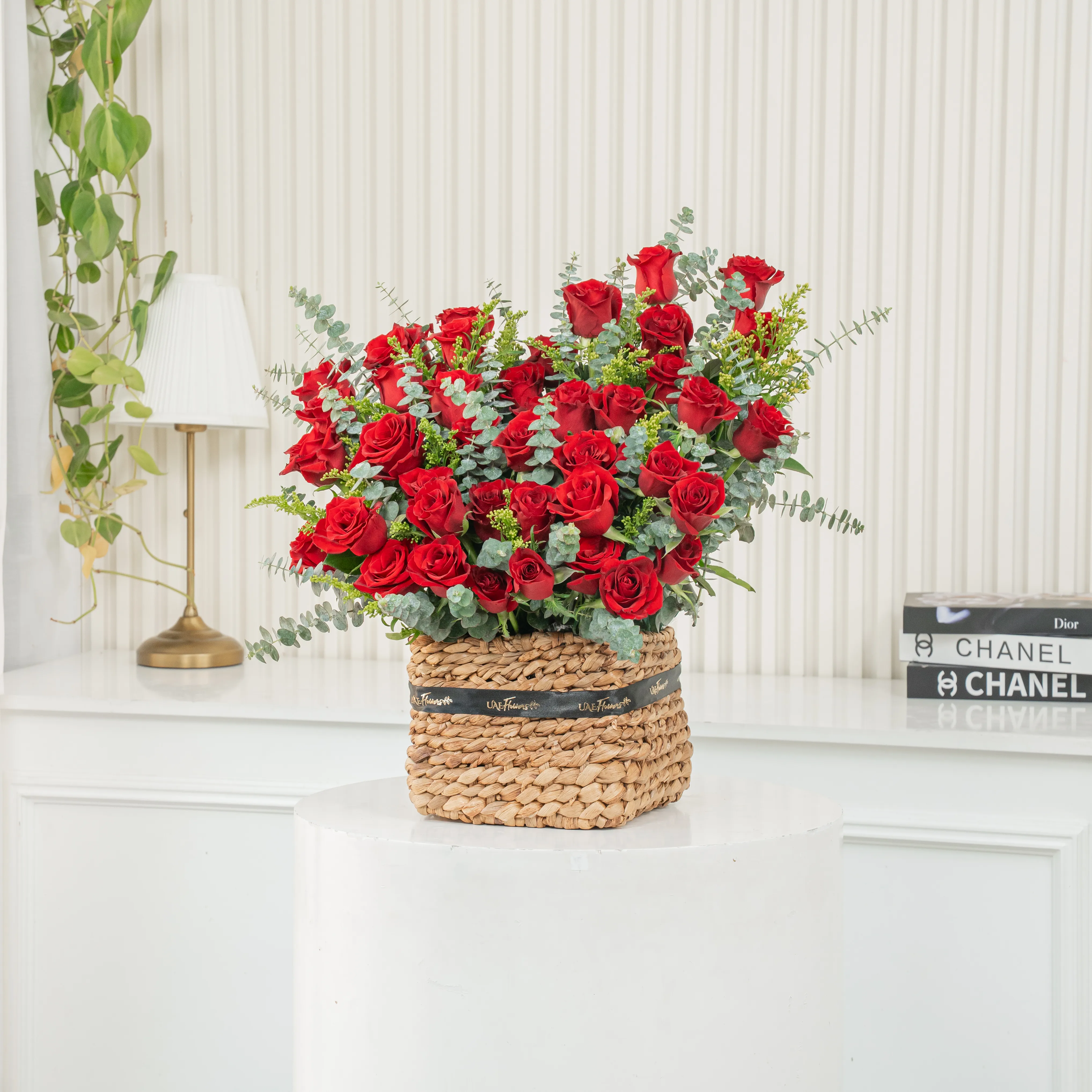 40 red roses with eucalyptus leaf in a square basket.