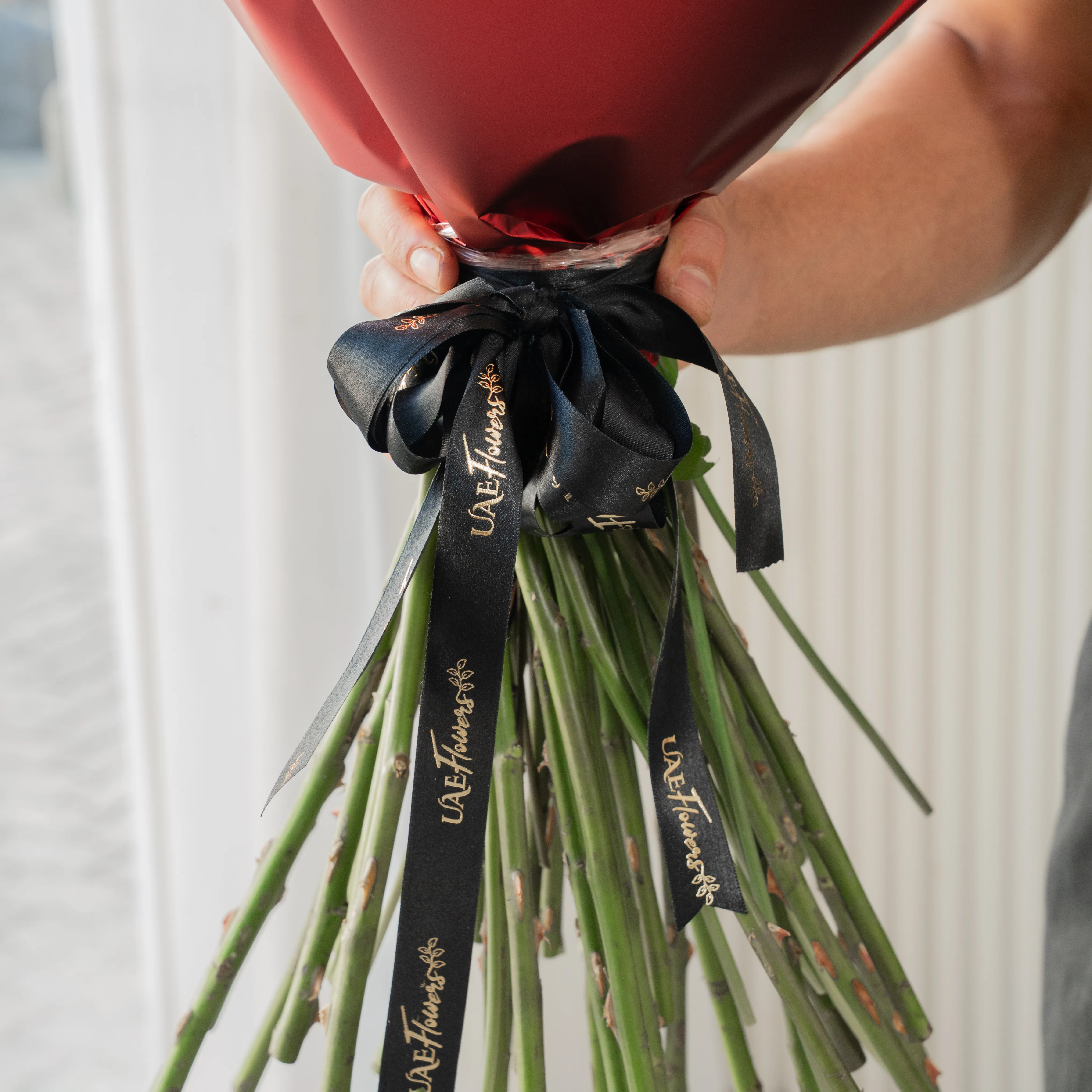 Bouquet of 30 red roses in paper packing hand-tied with ribbons.