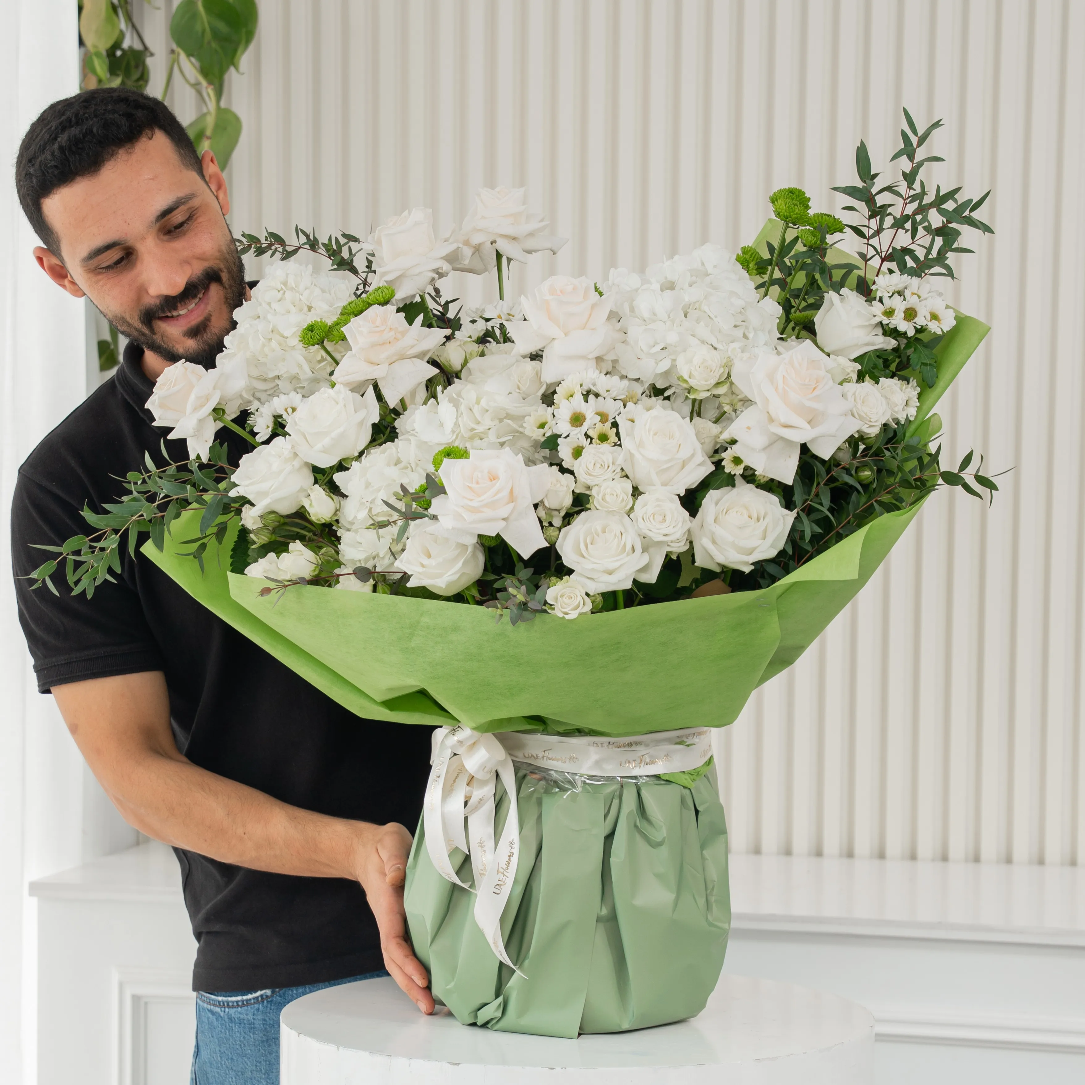 White Meadow bouquet with 16 white roses, 4 green chrysanthemums, and hydrangeas, tied with white ribbon—perfect for celebrations or thoughtful gifting.