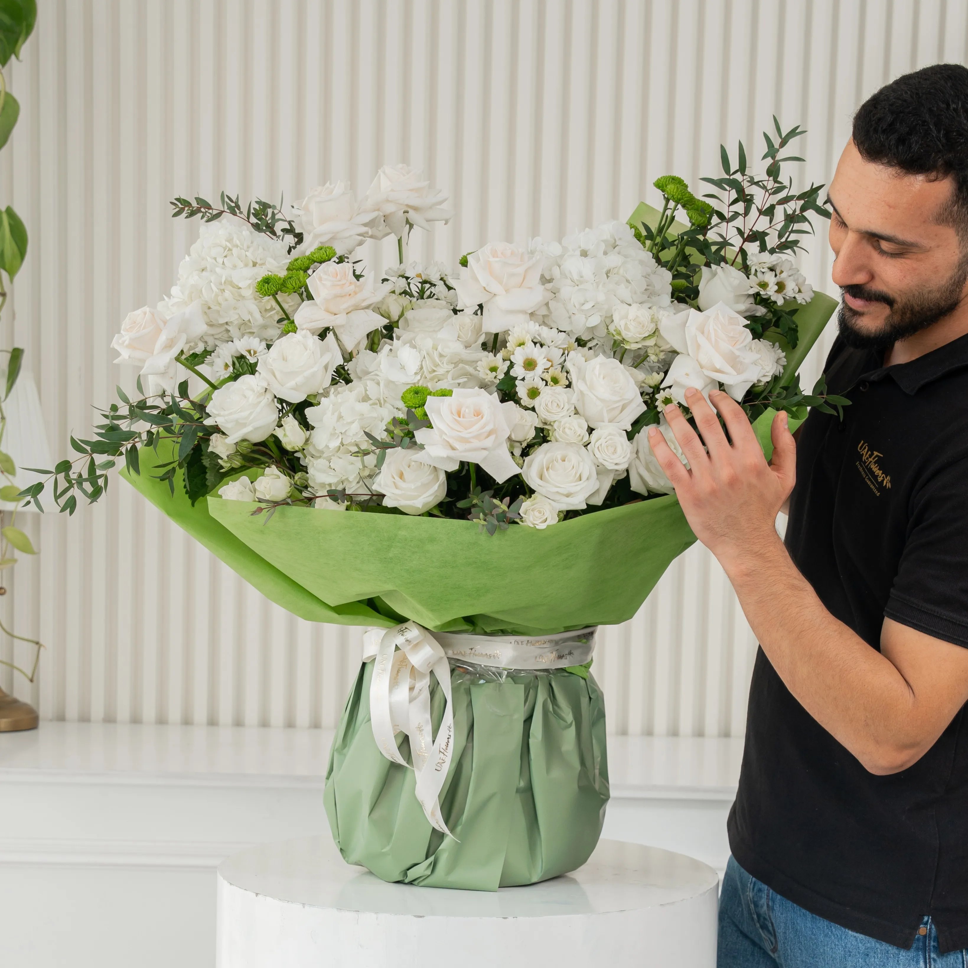 White Meadow bouquet with 16 white roses, 4 green chrysanthemums, and hydrangeas, tied with white ribbon—perfect for celebrations or thoughtful gifting.