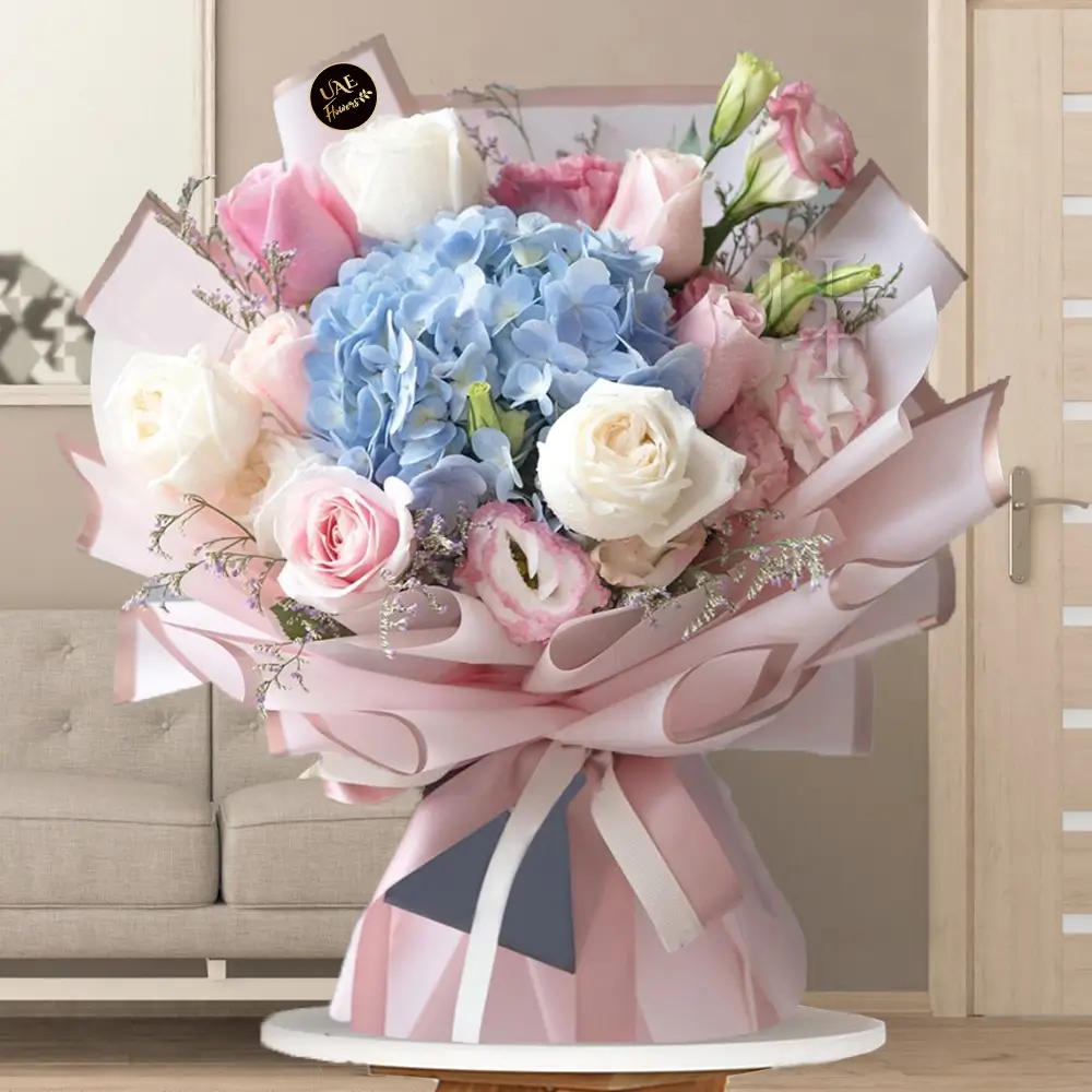 A dreamy pastel bouquet of 1 hydrangeas, 12 white and pink roses wrapped in pink paper with golden edges