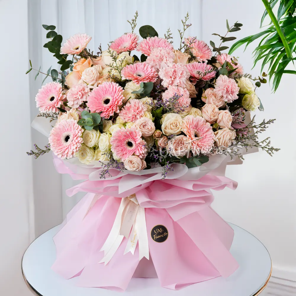 12 pink gerberas, 12 spray roses, and 12 carnations, wrapped